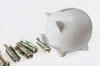 White piggy bank eating USA dollars one at a time, financial