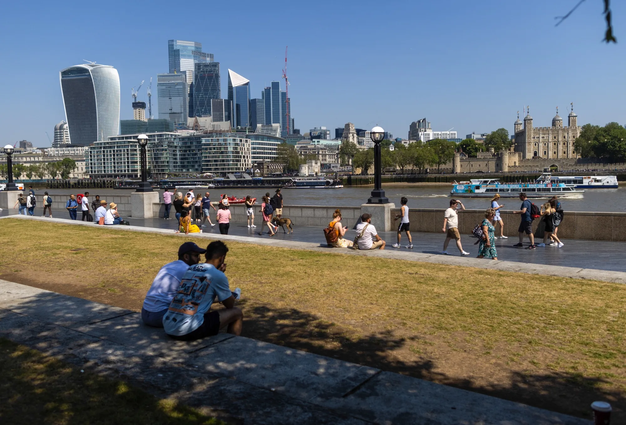 Visitors pass skyscrapers in the City of London, UK, on June 10.