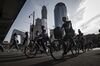 Cyclists pass pedestrians as they cycle along a road near the China Central Television (CCTV) headquarters building, left, in Beijing, China, on Monday, May 15, 2017. China's economy is staging a comeback as quickening inflation boosts factory profits, while stricter capital controls and a stabilizing currency help stem outflows.
