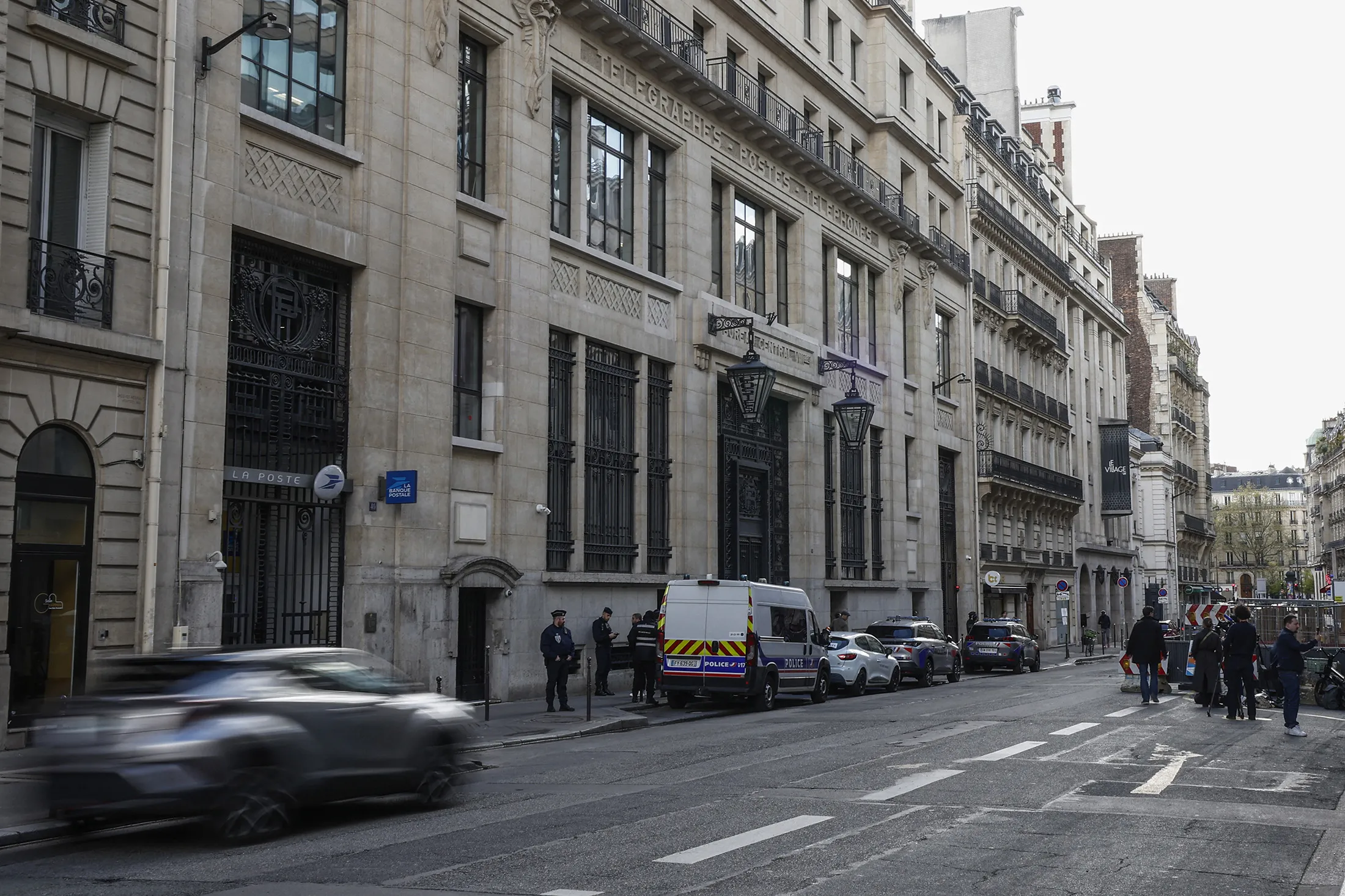 Police and security vehicles outside of the Bank of America building in the 8th arrondissement of Paris on March 28.