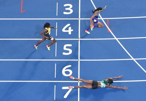 The Bahamas' Shaunae Miller dives to cross the finish line ahead of USA's Chase Kalisz during the women's 400-meter final.