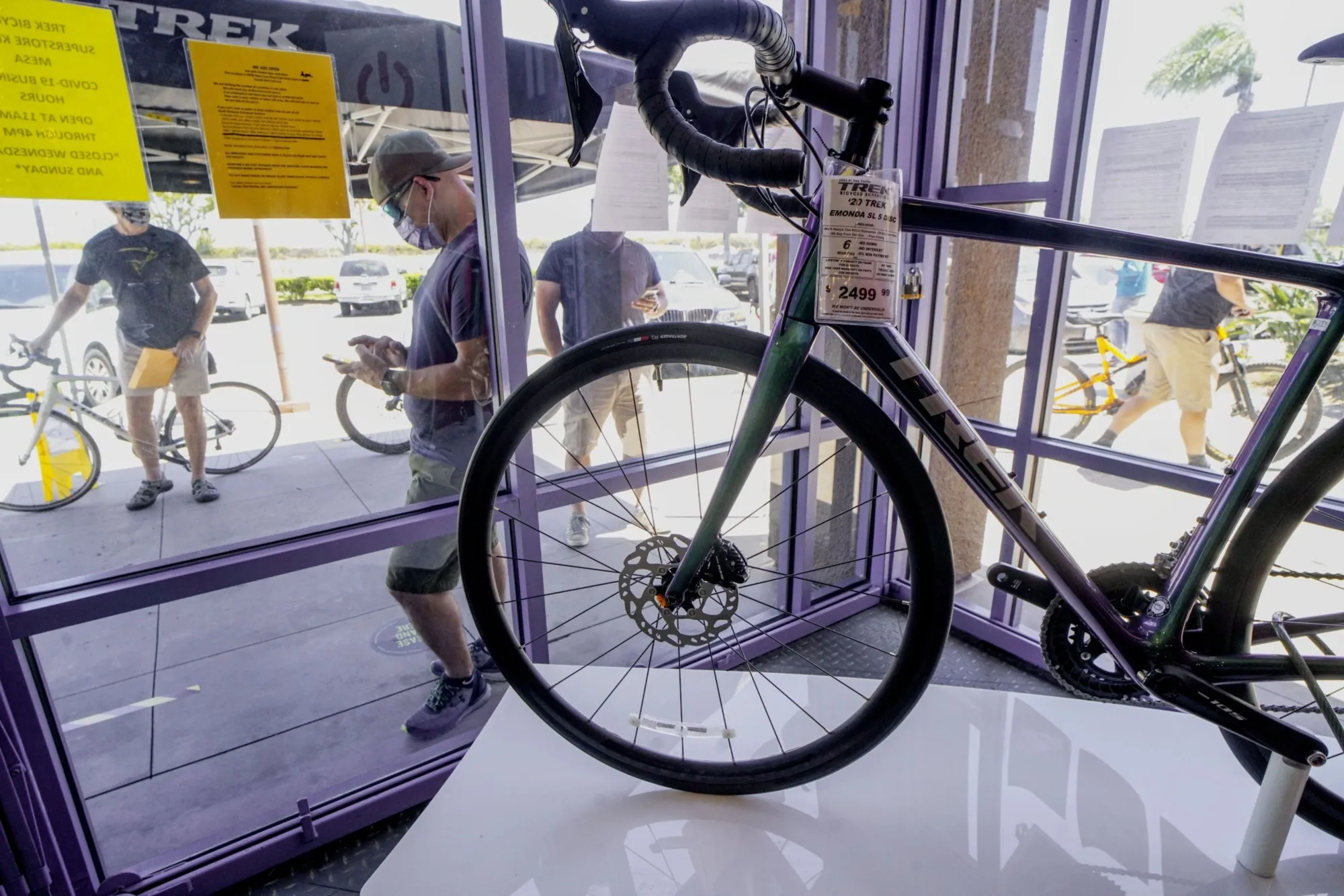 Customers wearing protective masks wait in line to enter the Trek Bicycle Shop in San Diego.&nbsp;