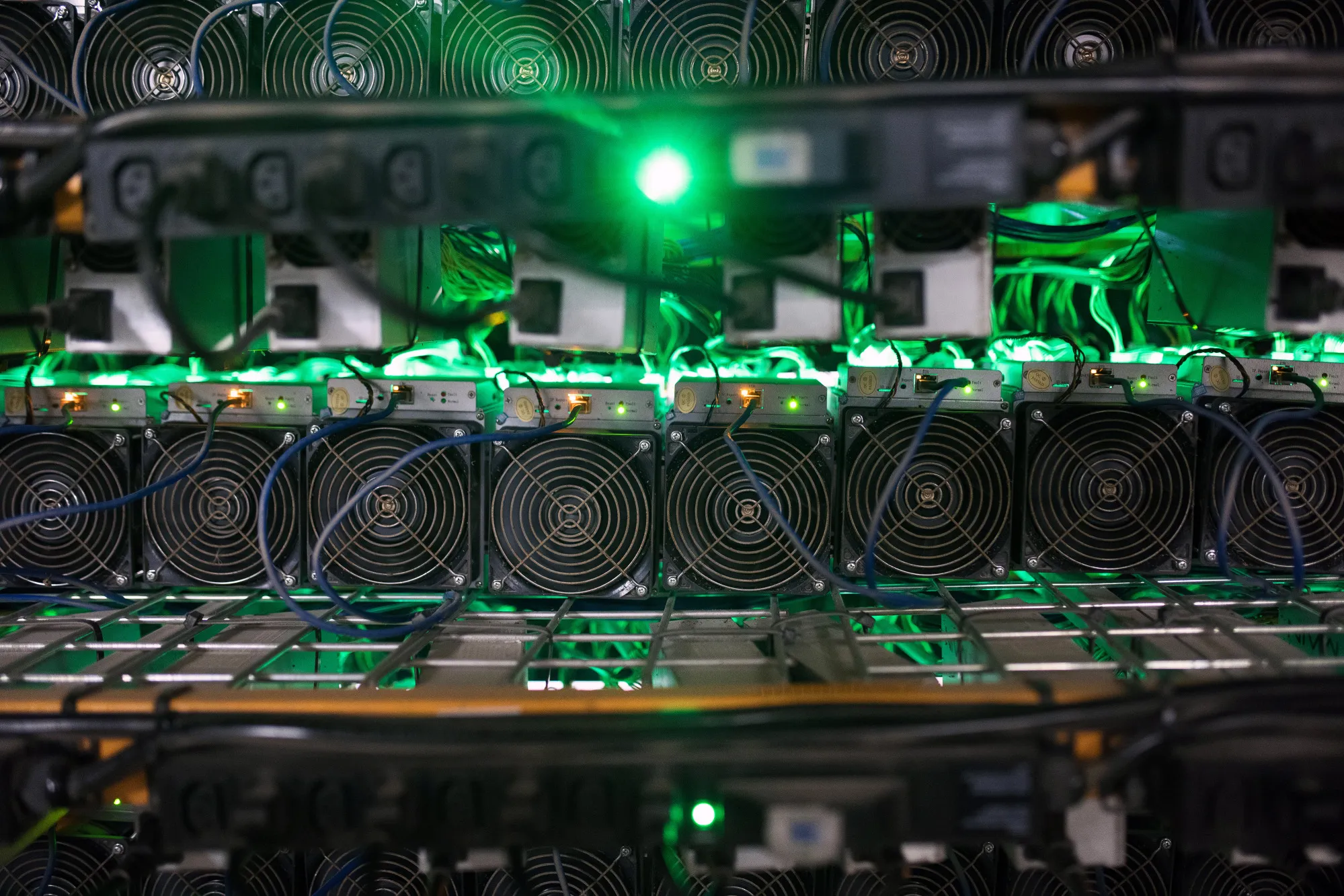 Cryptocurrency mining rigs sit on racks at a facility