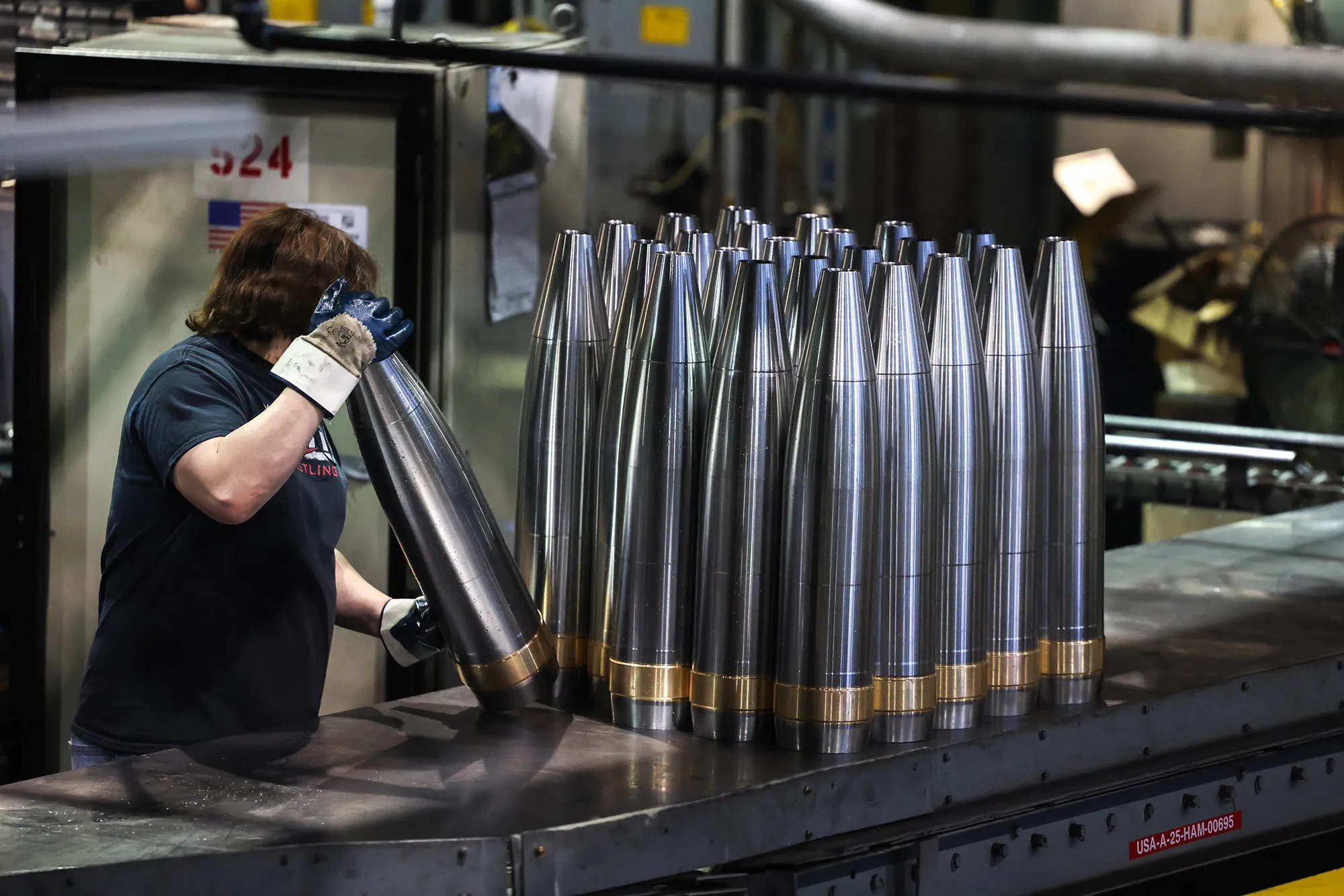An employee handles 155 mm caliber shells after the manufacturing process at the Scranton Army Ammunition Plant in Scranton, Pennsylvania.