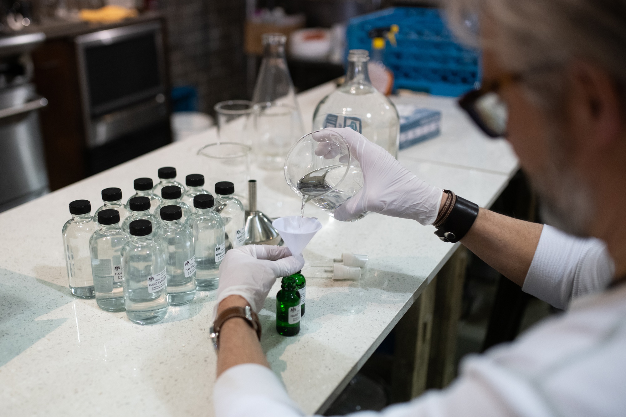 A worker fills a bottle with a hand-held cleaning solution made from sediment alcohol products at a distillery in Seattle in March 2020.