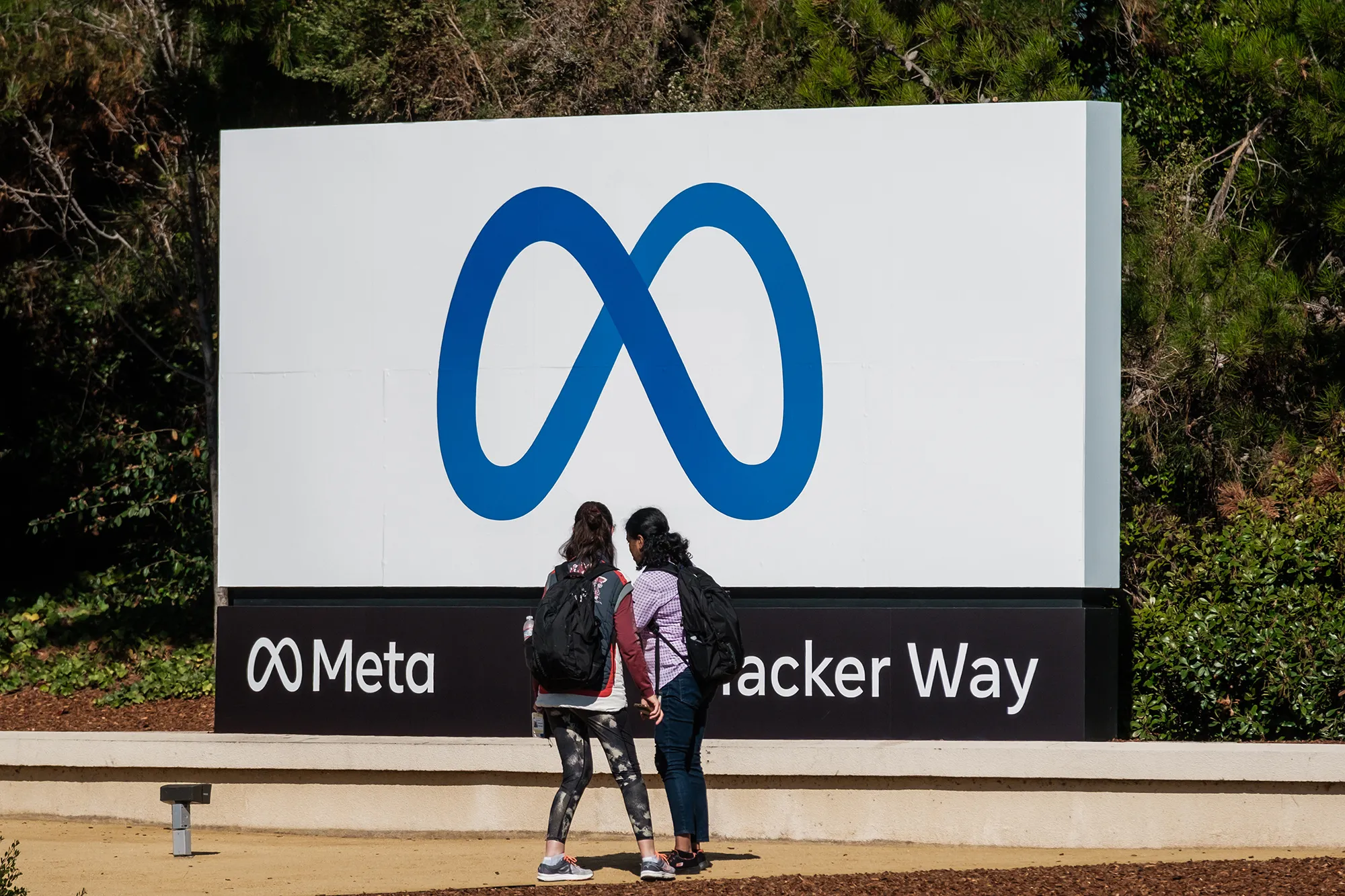 Visitors take photographs in front of signage at Meta Platforms headquarters in Menlo Park, California.