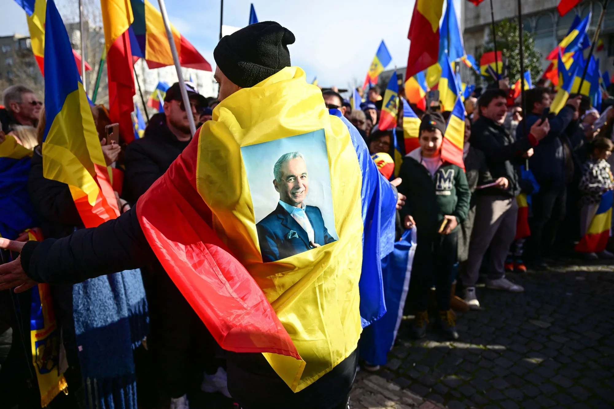 A man wearing a Romanian flag with a portrait of presidential candidate Călin Georgescu in Bucharest on Jan. 24.