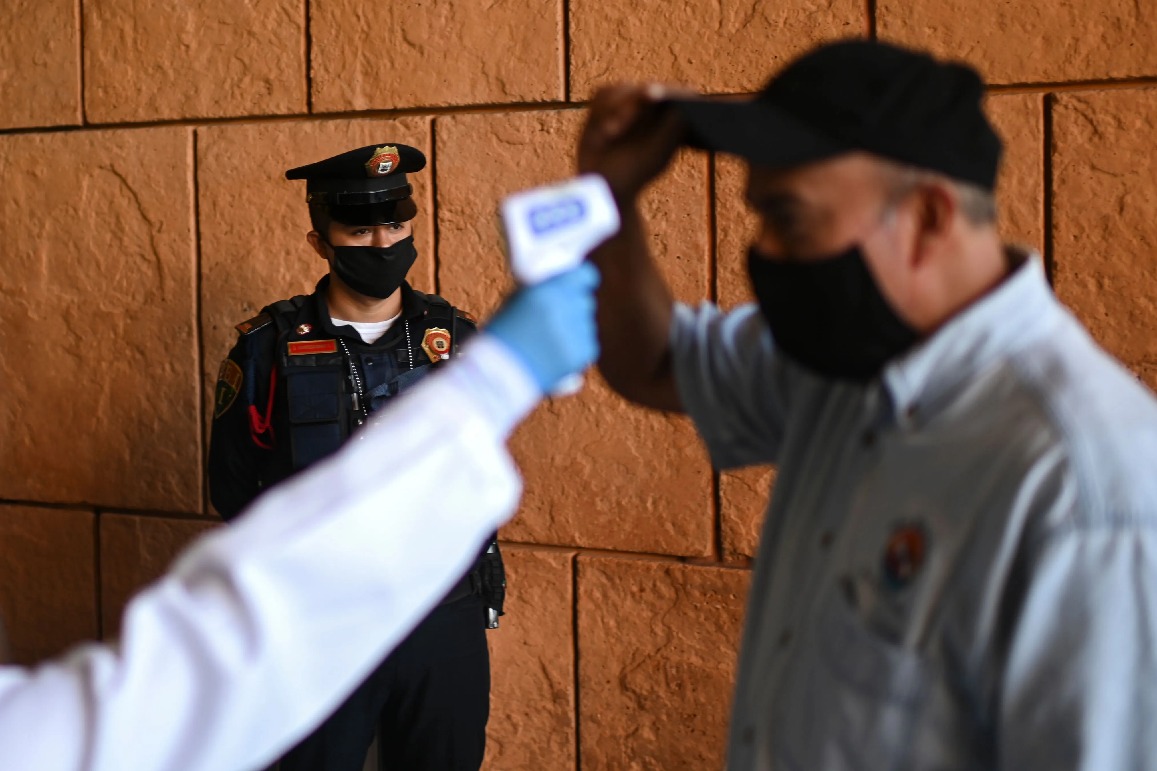 A woman checks the body temperature of a visitor at a mall in Mexico City on July 8.