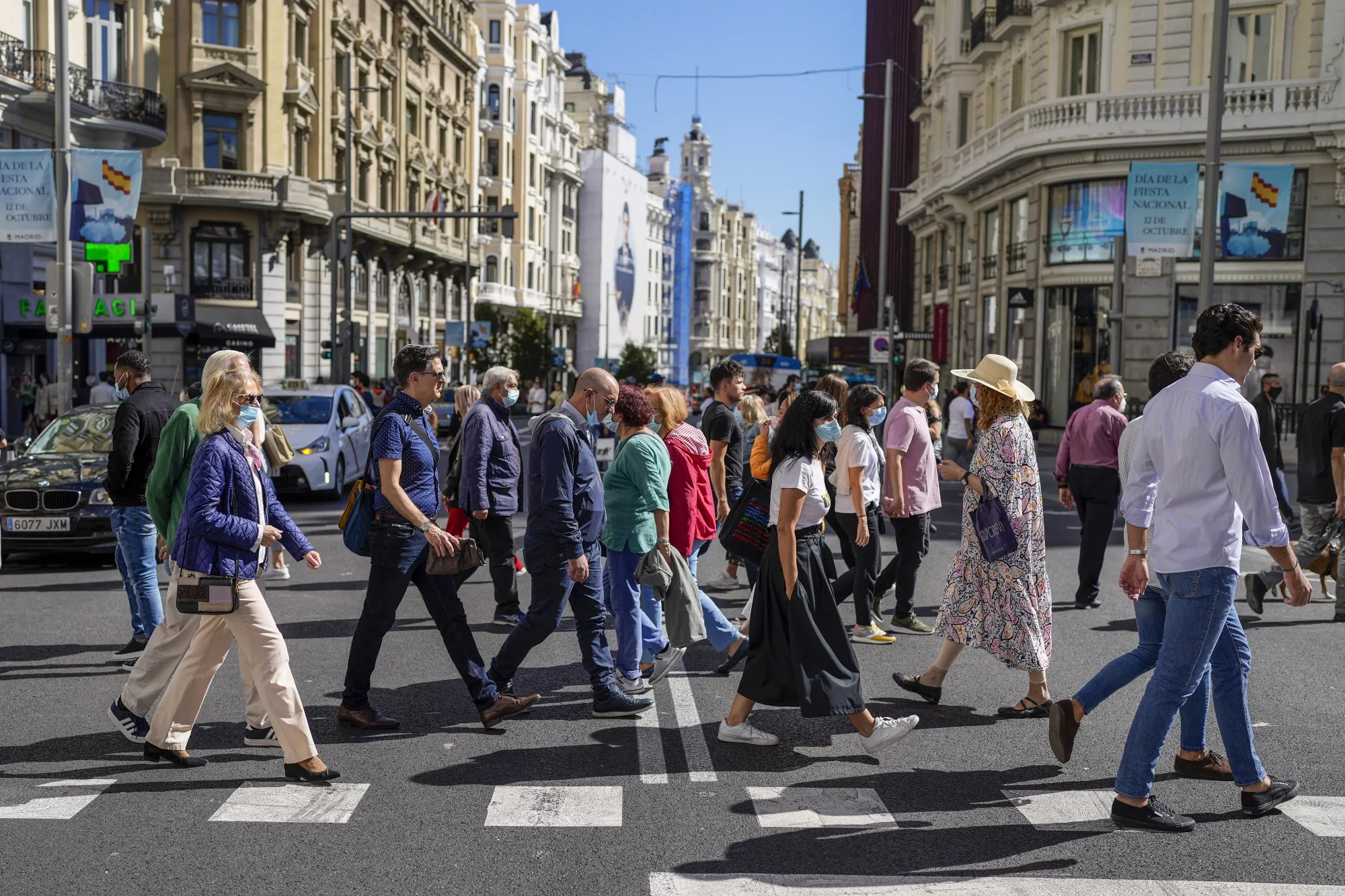 Shoppers cross the Gran Via in Madrid, Spain.