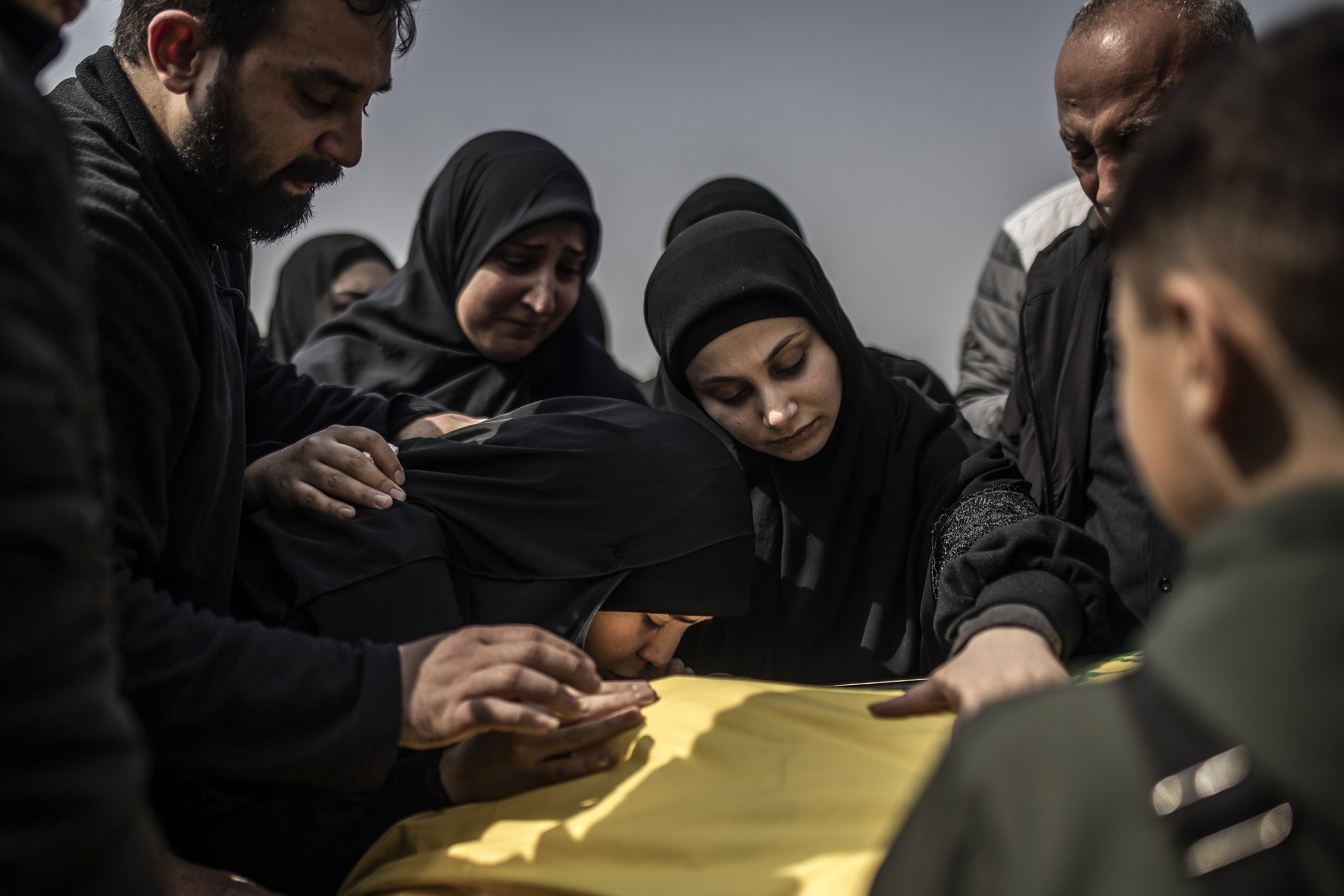 BEIRUT, LEBANON - MARCH 19: Neighbors and relatives gather for the funeral of Al-Manar journalist Mohammad Sherri, his wife, and paramedic Bassel Atwi in the Dahieh district of southern Beirut, Lebanon, on March 19, 2026. Sherri and his wife lost their lives after an Israeli airstrike targeted their residential building in the Zuqaq al-Blat neighborhood, while Atwi lost his life in a separate incident. Atwi was a paramedic. The bodies are buried in two consecutive burials as part of the same ceremony, which draws hundreds of people amid rising tensions between Israel and Hezbollah. (Photo by Bruno Thevenin/Anadolu via Getty Images) Photographer: Anadolu/Anadolu