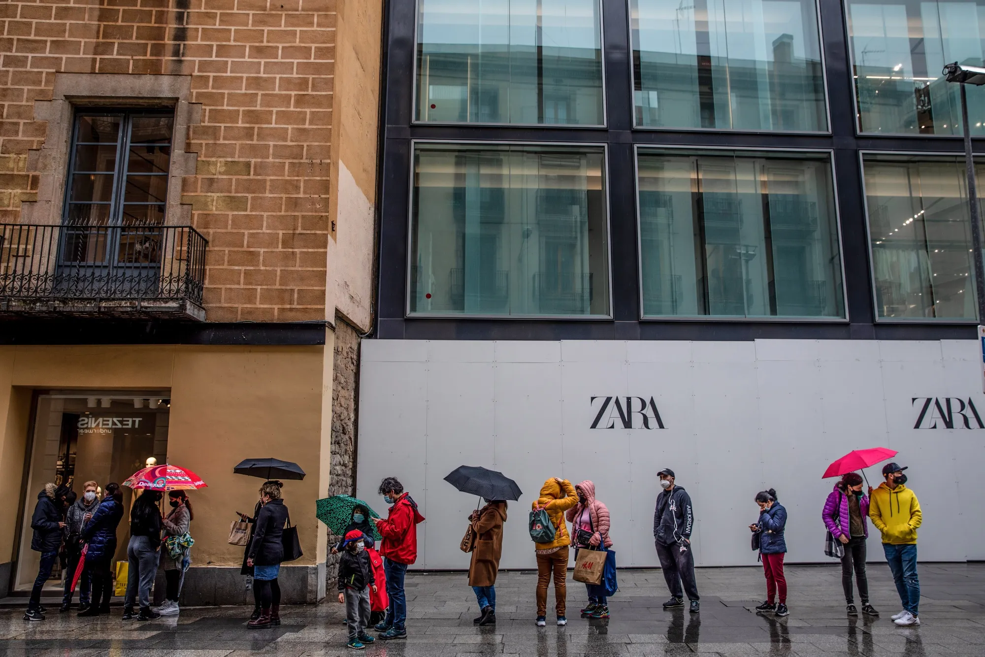 Shoppers wait outside a Zara clothing store in Barcelona in early March.
