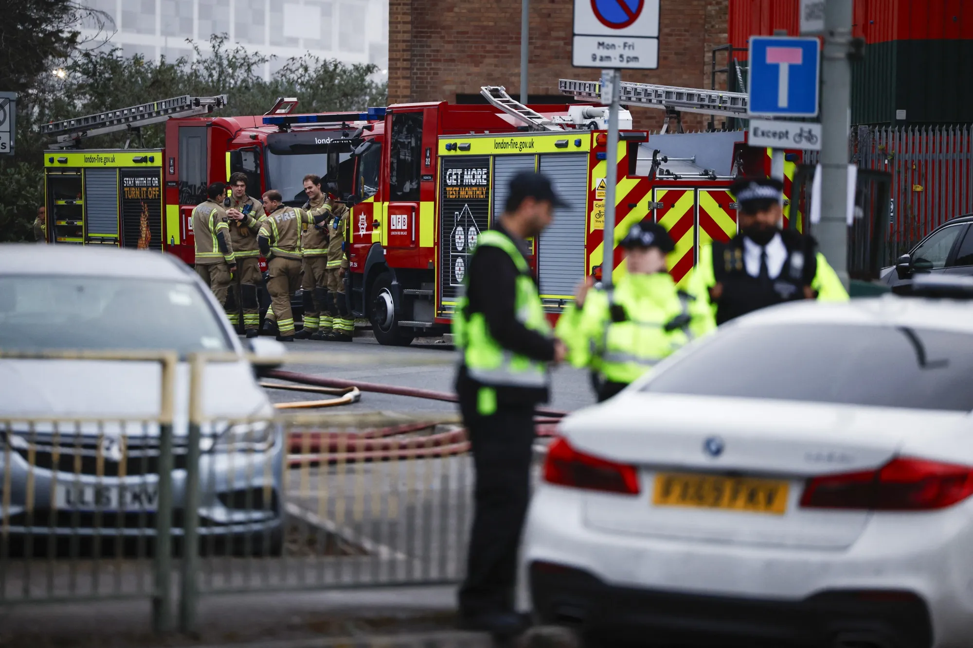 Police officers and firefighters near the scene of a fire at a power substation serving Heathrow airport.