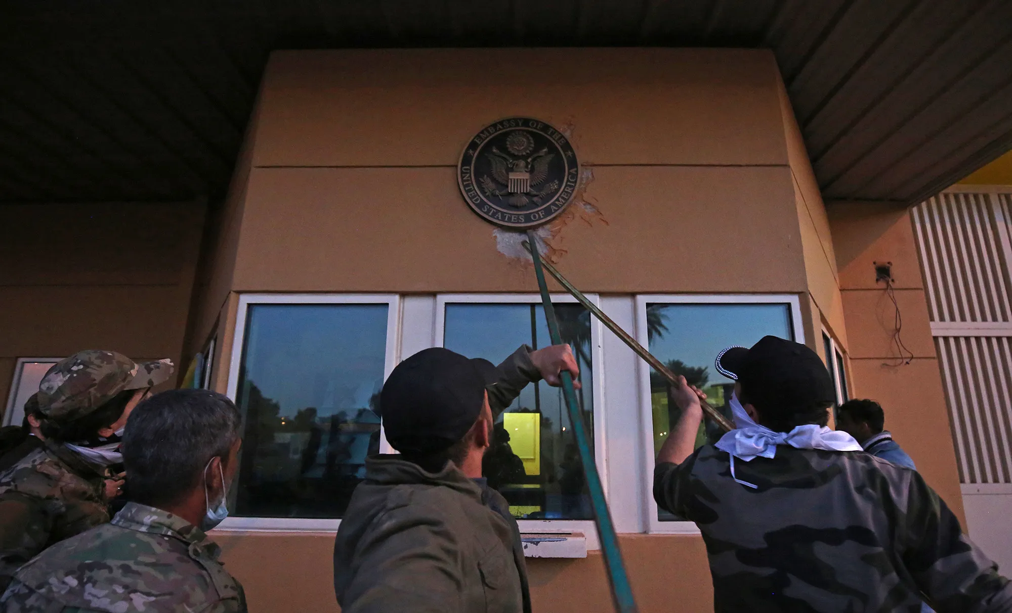 Protesters pull off a plaque from the entrance of the U.S. embassy in Baghdad&nbsp;on Dec. 31, 2019.