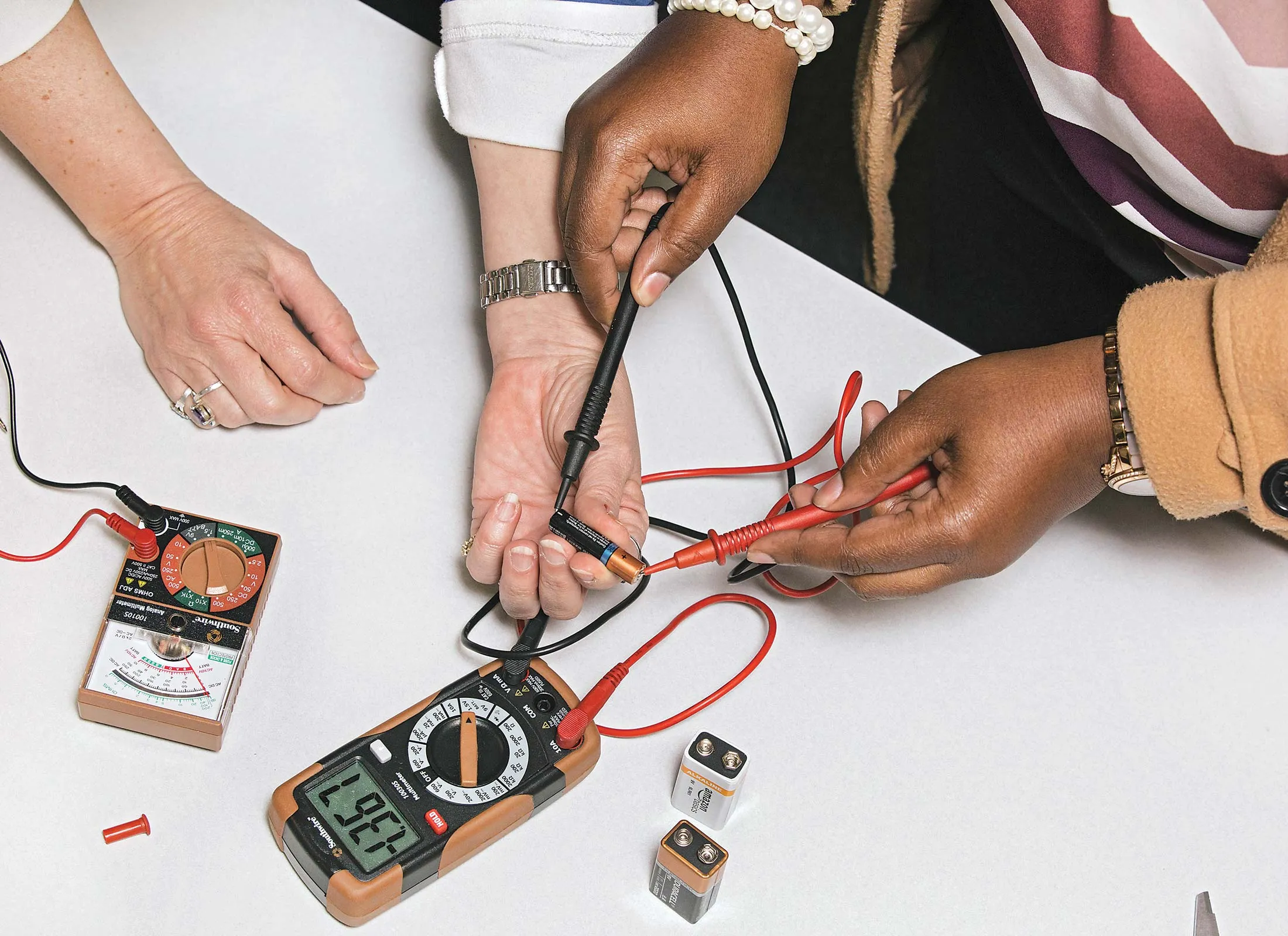 An instructor demonstrates how to use an ohmmeter, which measures electrical resistance.
