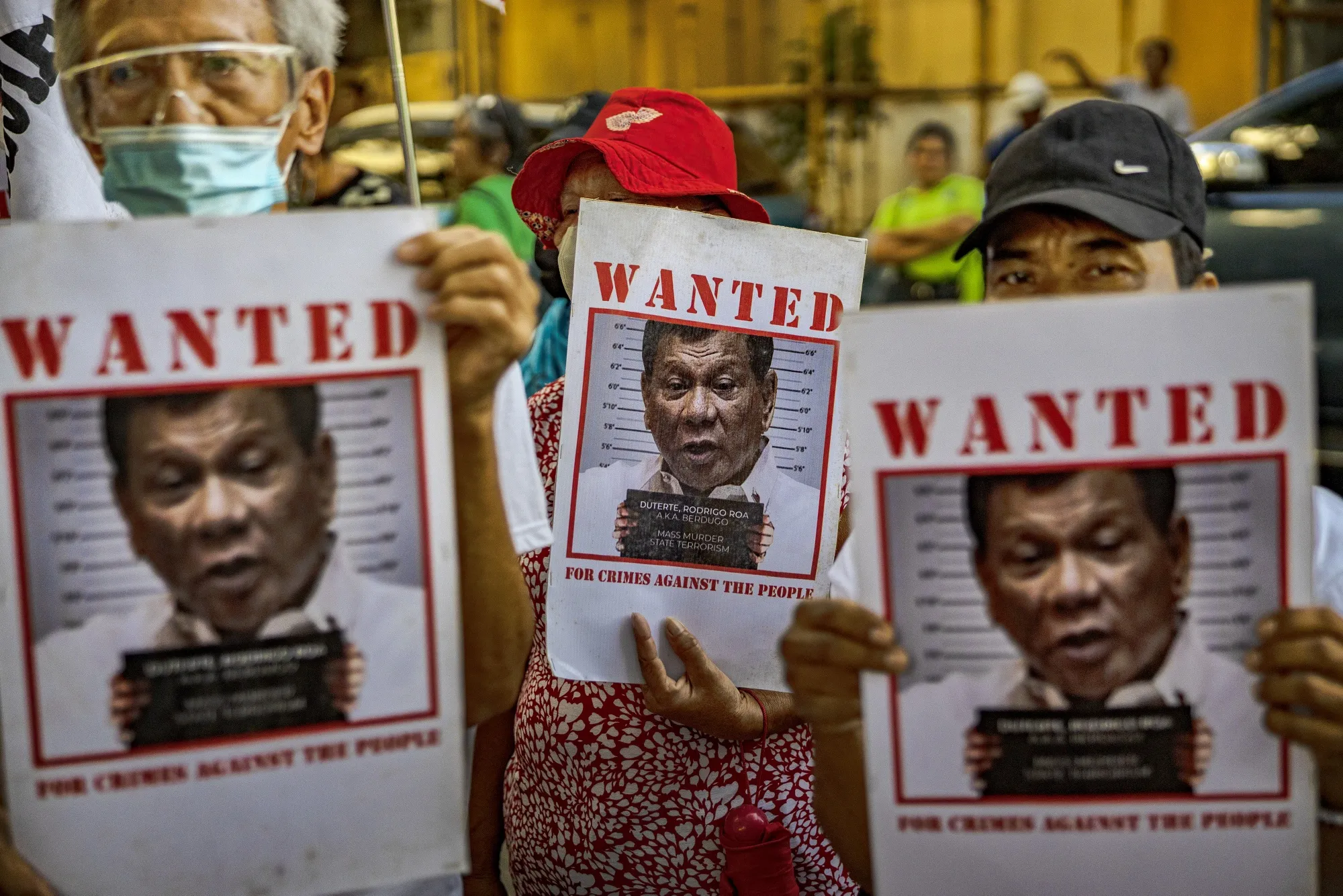 People hold sign outside the Quezon City Prosecutor’s Office which summoned Duterte over a criminal complaint filed against him in Quezon City in Dec. 2023.