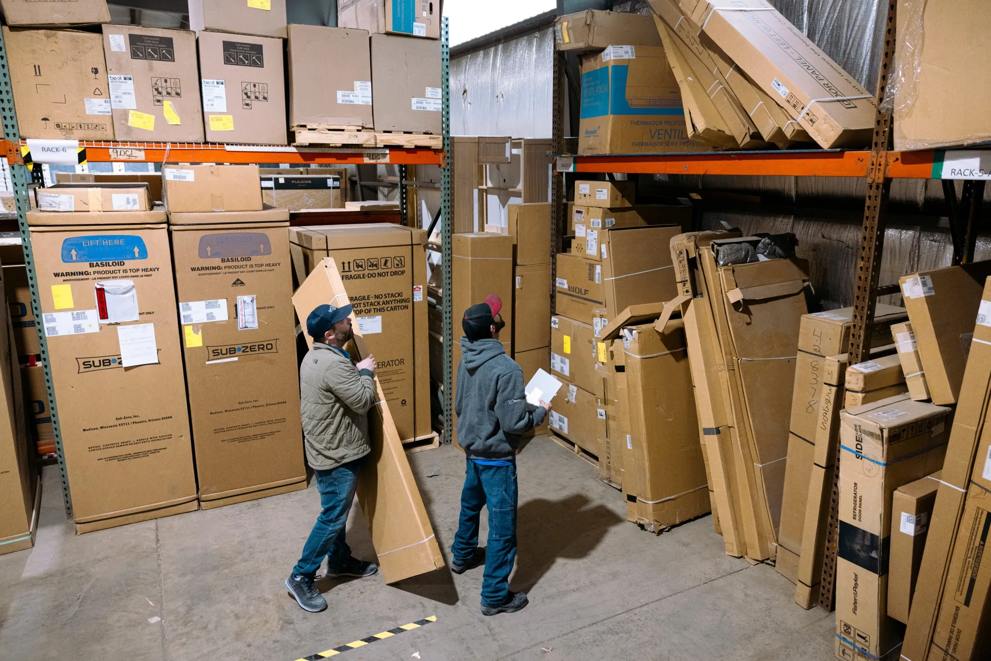 Workers move boxes of appliance parts in a warehouse in Latham, New York.
