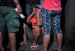 A relative weeps near the body of a man who was killed following a police operation against illegal drugs in Manila, Philippines, early Aug. 17.