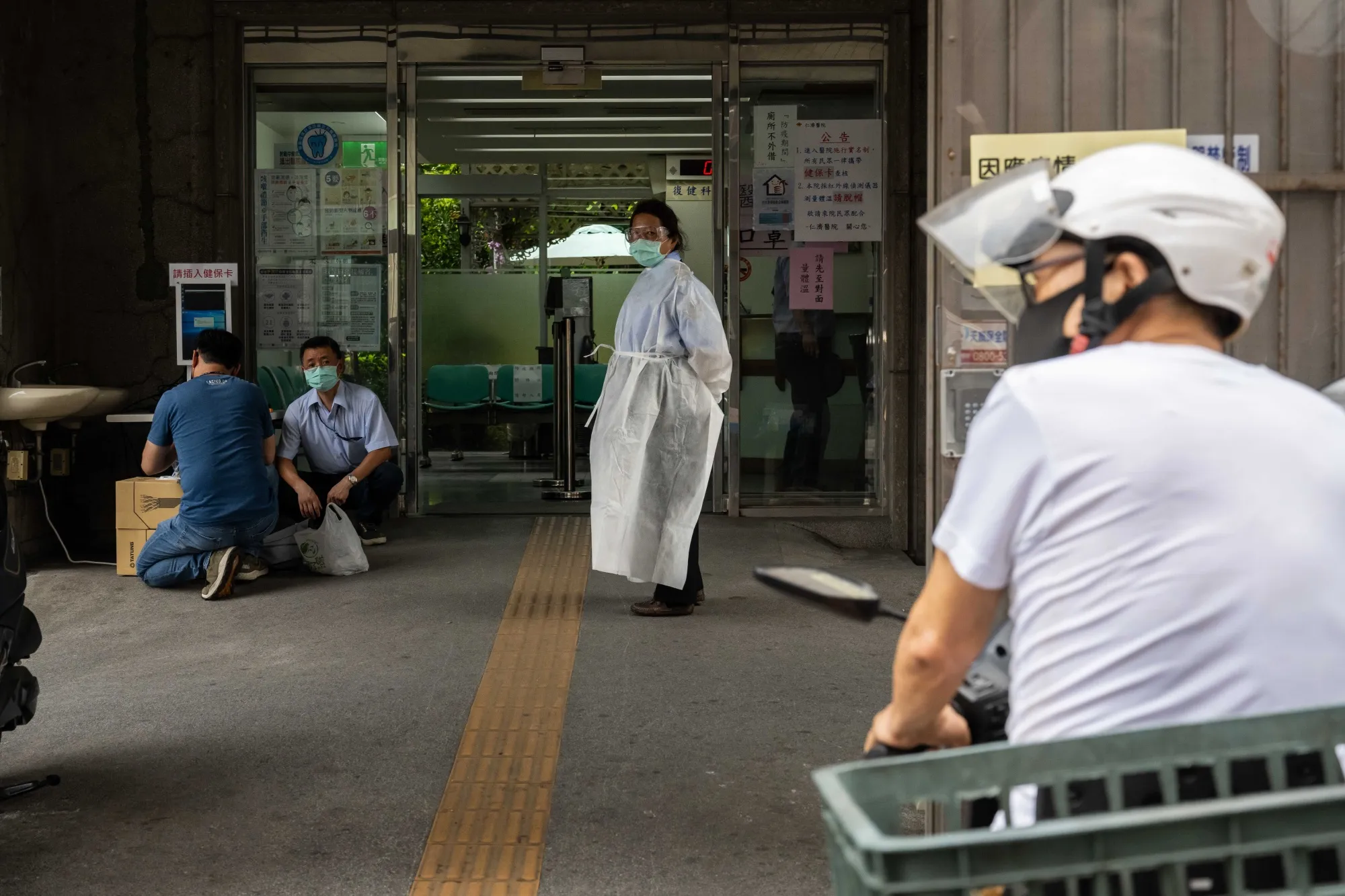 A worker stands in front of a hospital entrance in Taipei on May 17.