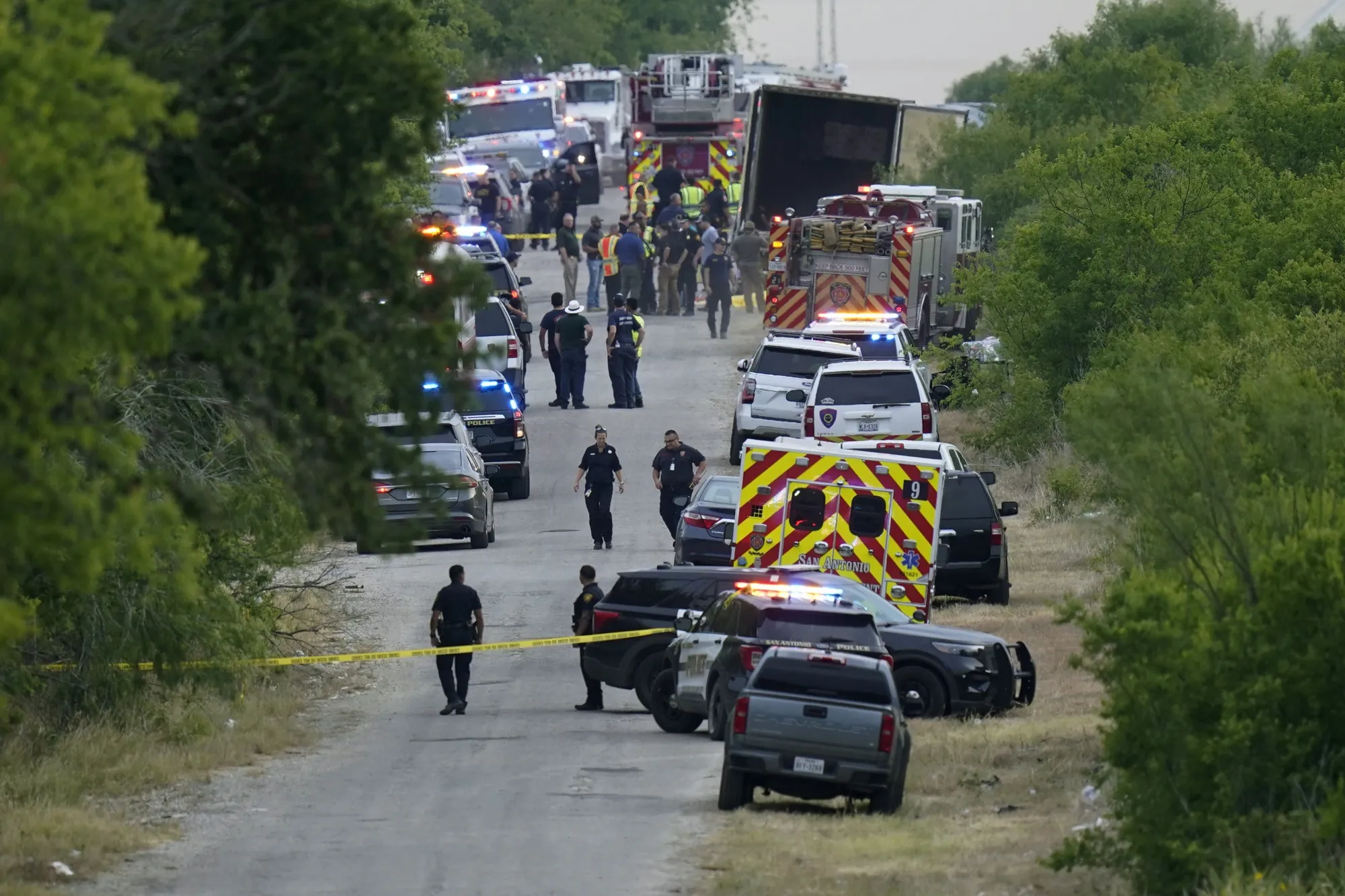 Police at the scene where dozens of people were found dead in a semitrailer in a remote area in southwestern San Antonio, on June 27.