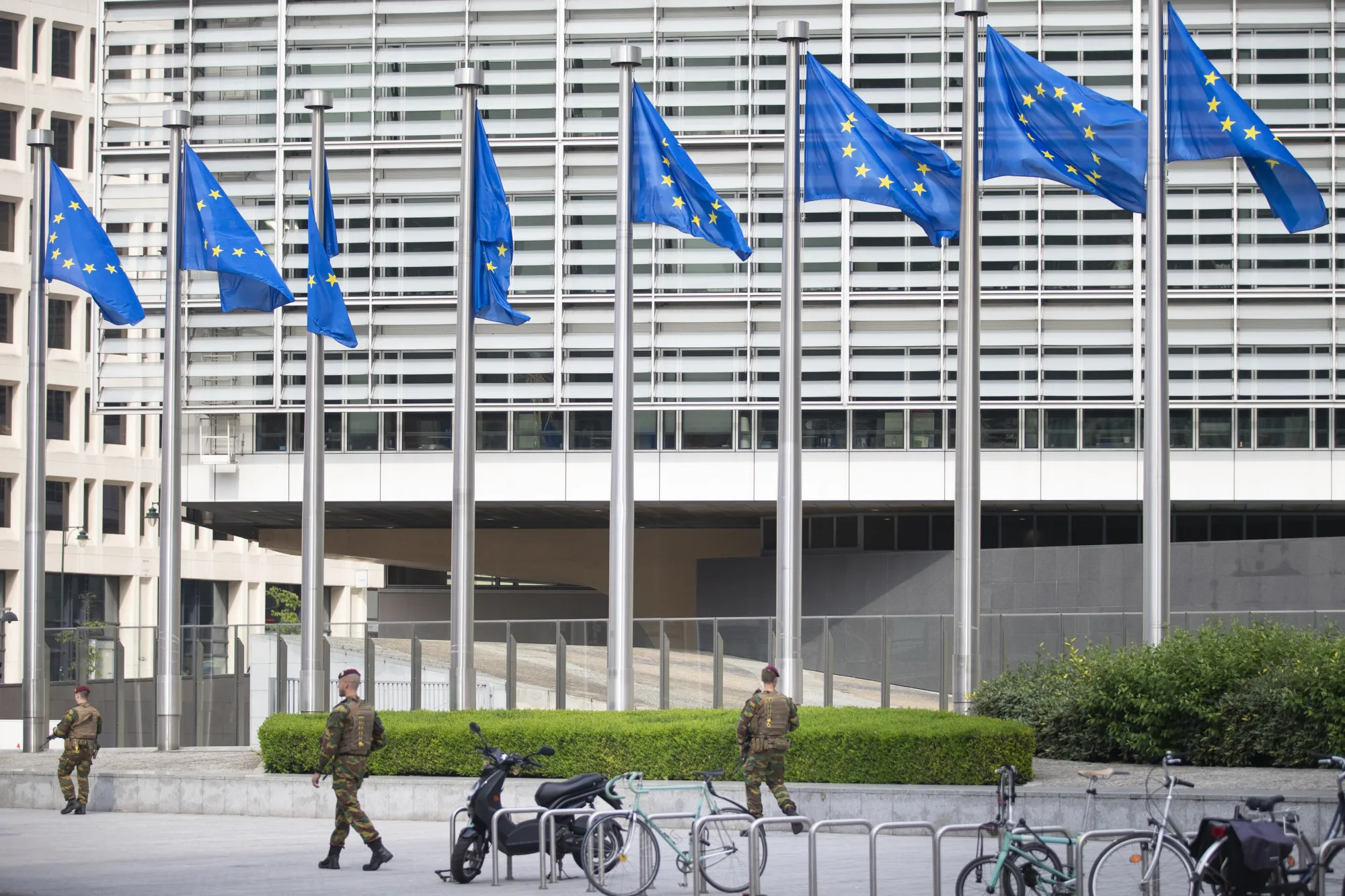 Soldiers walk past the European Commission Berlaymont building as European Union (EU) flags fly in Brussels, Belgium.
