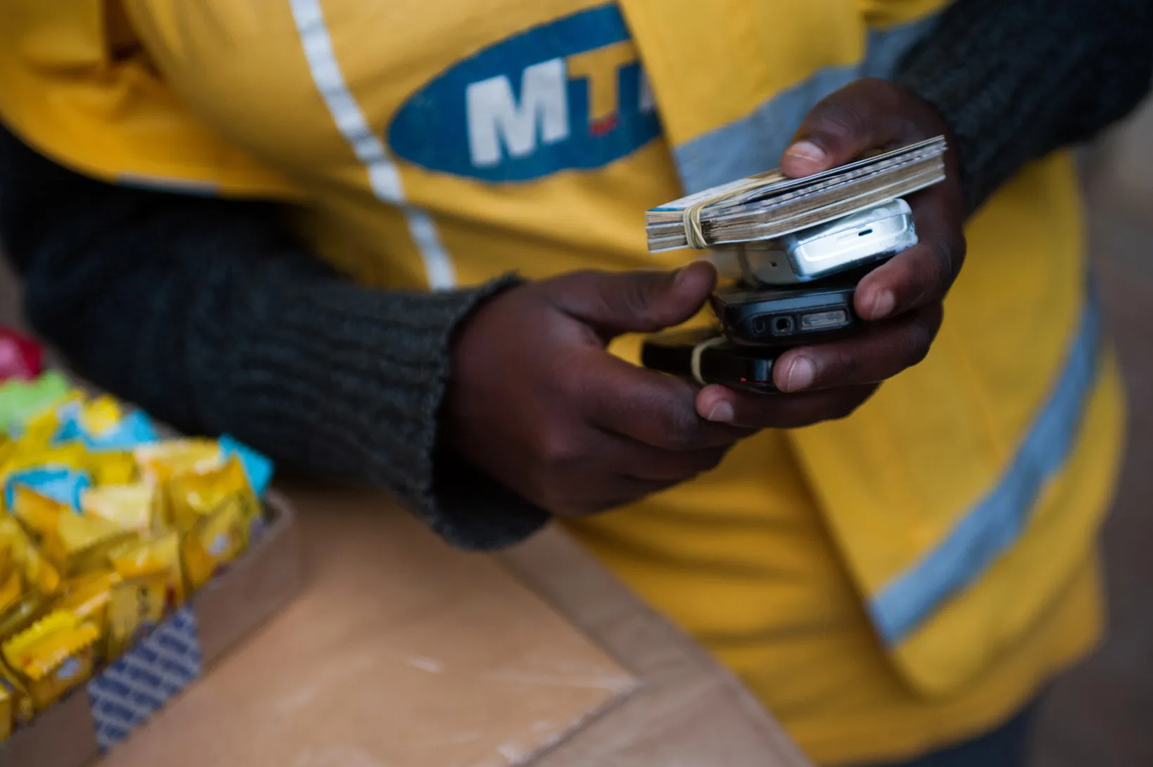 A vendor holds mobile phones&nbsp;at a Mobile Money stall&nbsp;in Kigali, Rwanda.