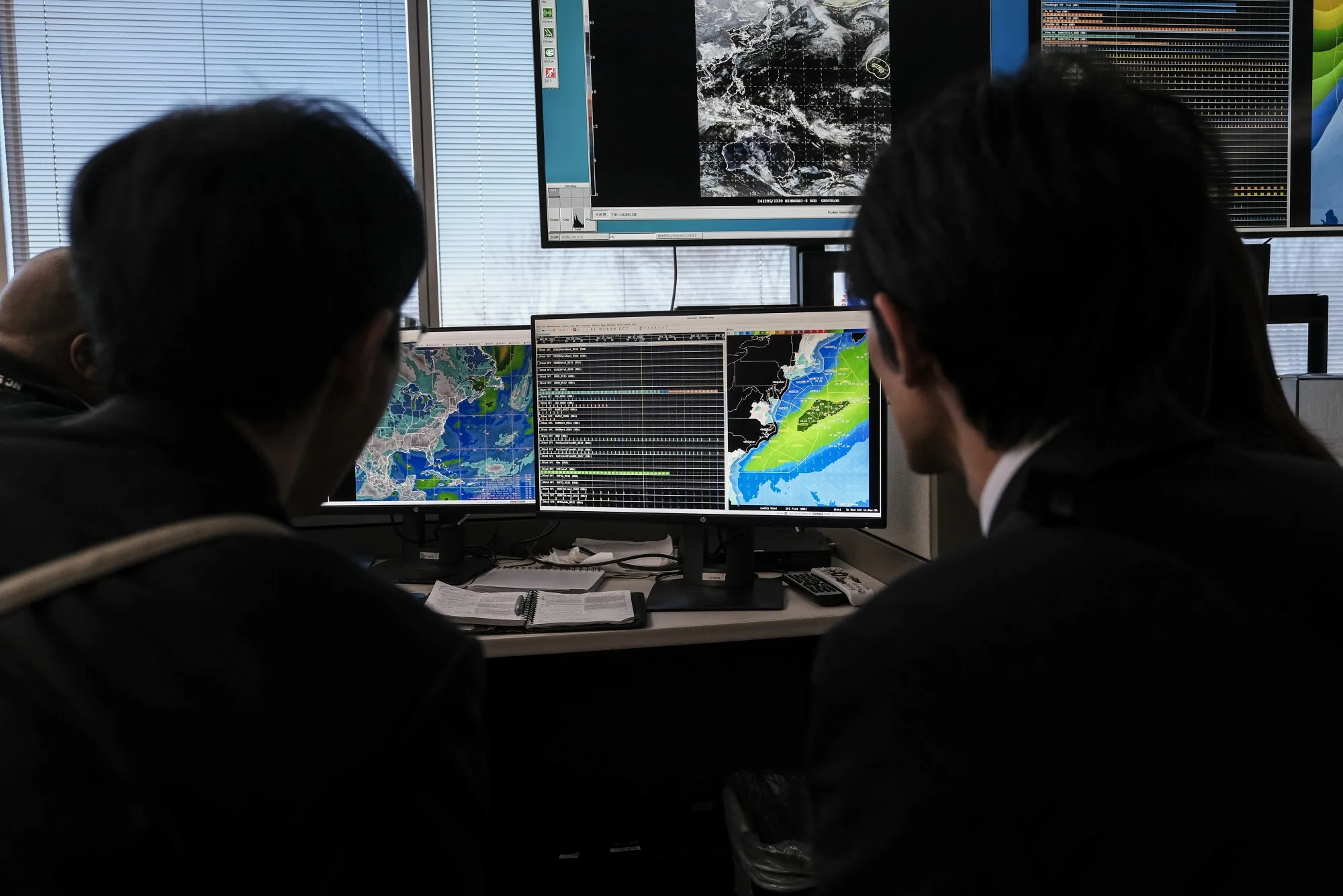 Meteorologists and members of the Japan Meteorological Agency monitor weather activity on a computer screen at the NOAA Center for Weather and Climate Prediction headquarters in College Park, Maryland in December 2024. NOAA has been plunged into turmoil as the Trump administration attempts to reshape the federal bureaucracy.