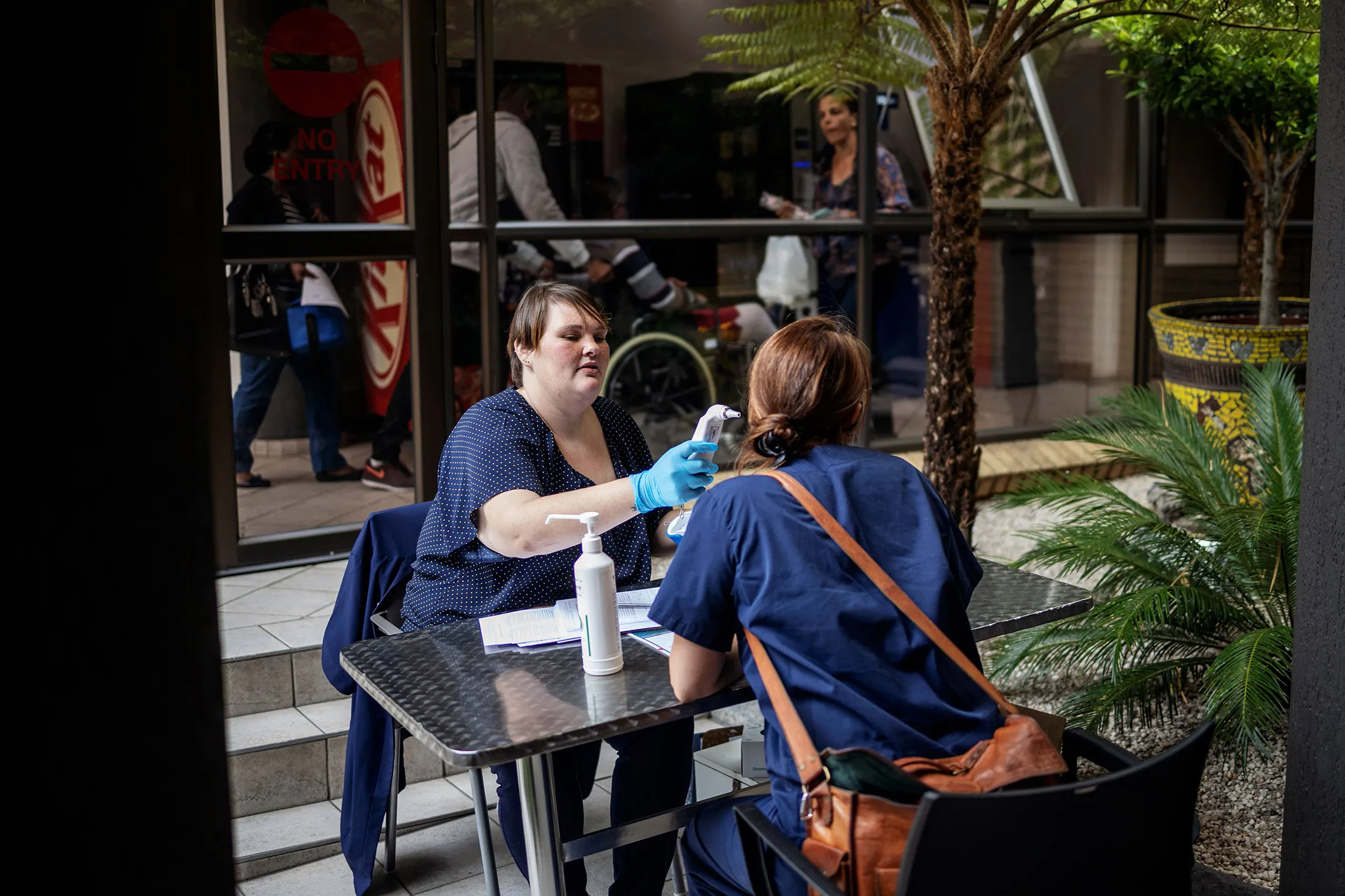 An assistant measures the temperature of an incoming visitor of the Netcare Sunninghill Hospital in Johannesburg&nbsp;on March 12.