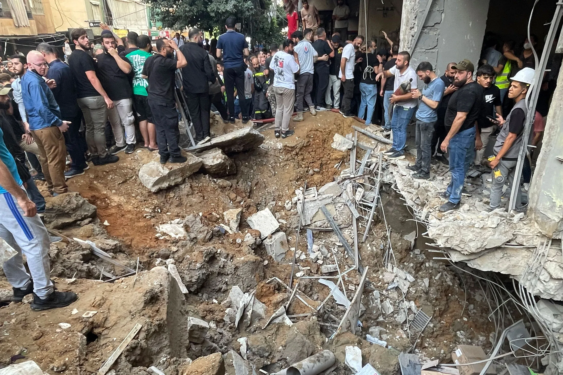 People gather at the scene of an Israeli strike in southern Beirut, on Sept. 20.