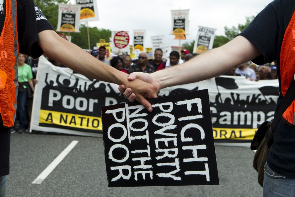 Clasped hands in front of a banner at the Poor People's Campaign rally in Washington, D.C. on Saturday, June 23, 2018.