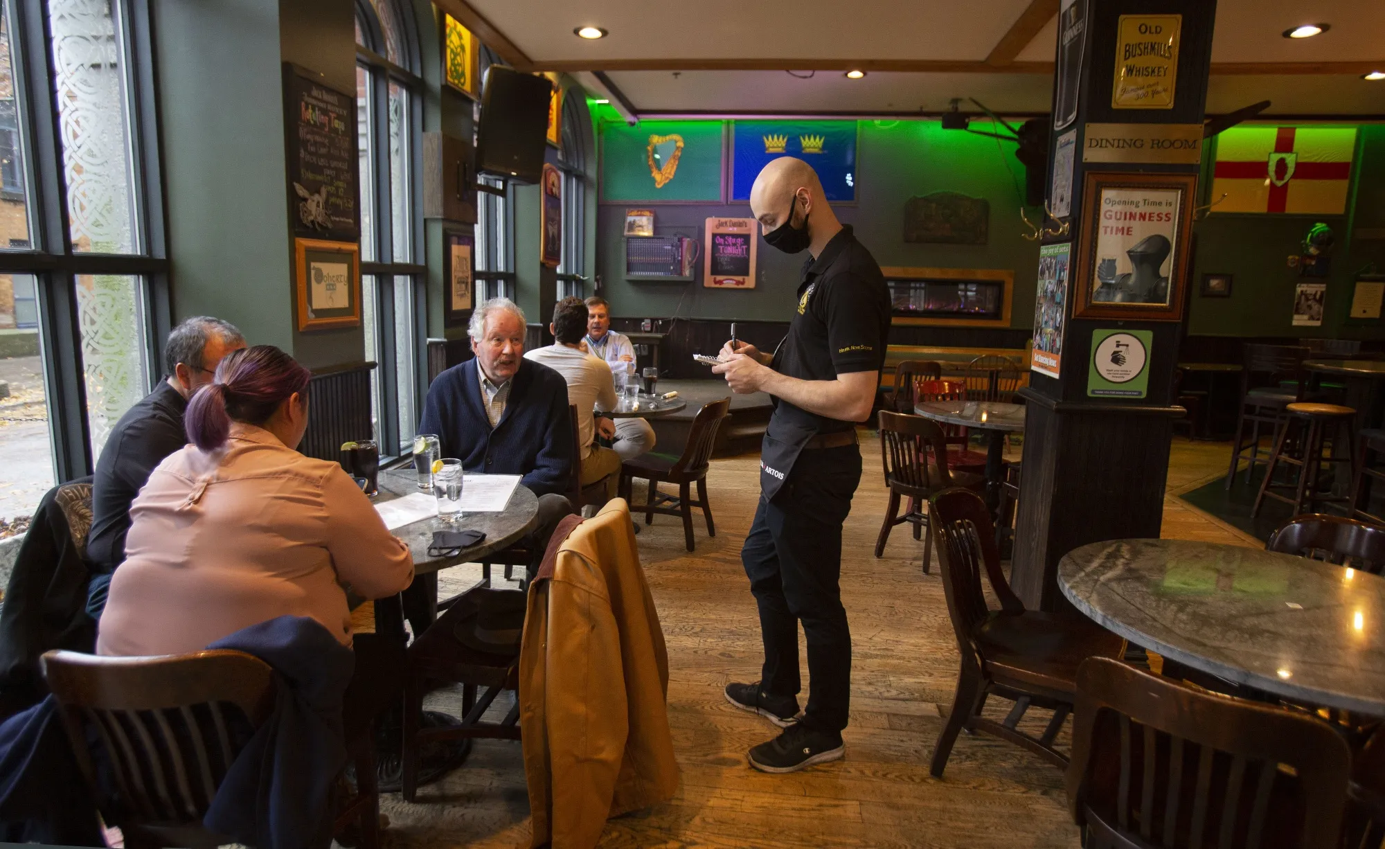 Diners eat indoors at a pub in Halifax, Nova Scotia, where group gathering limits have been raised.