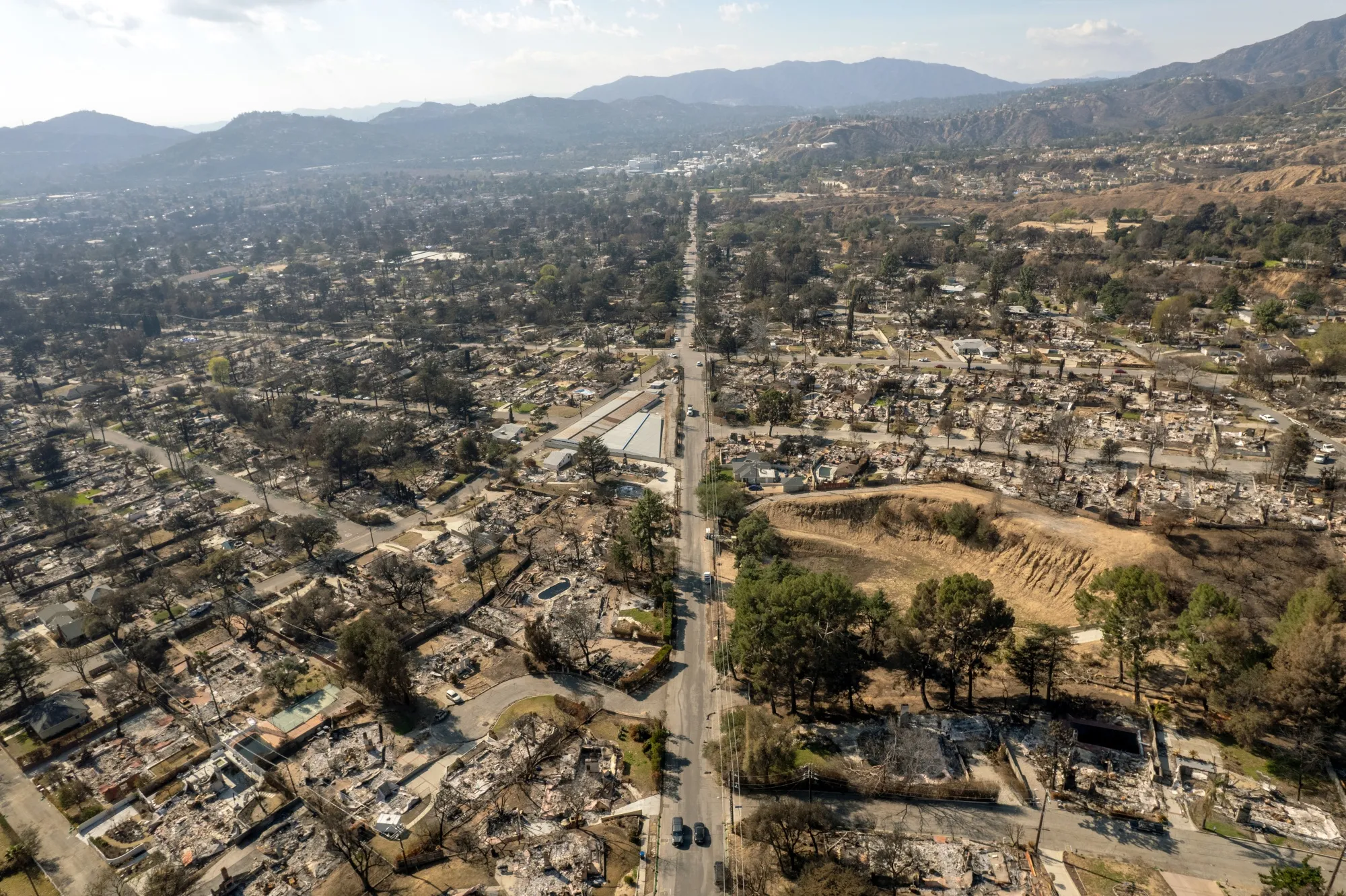 Altadena’s East Alta Loma Drive seen from above on Feb. 11, 2025. The area on the north side, right, is&nbsp;in a designated fire hazard zone while the south side, left, is not. Homes on both sides of the road burned in the Eaton Fire.&nbsp;