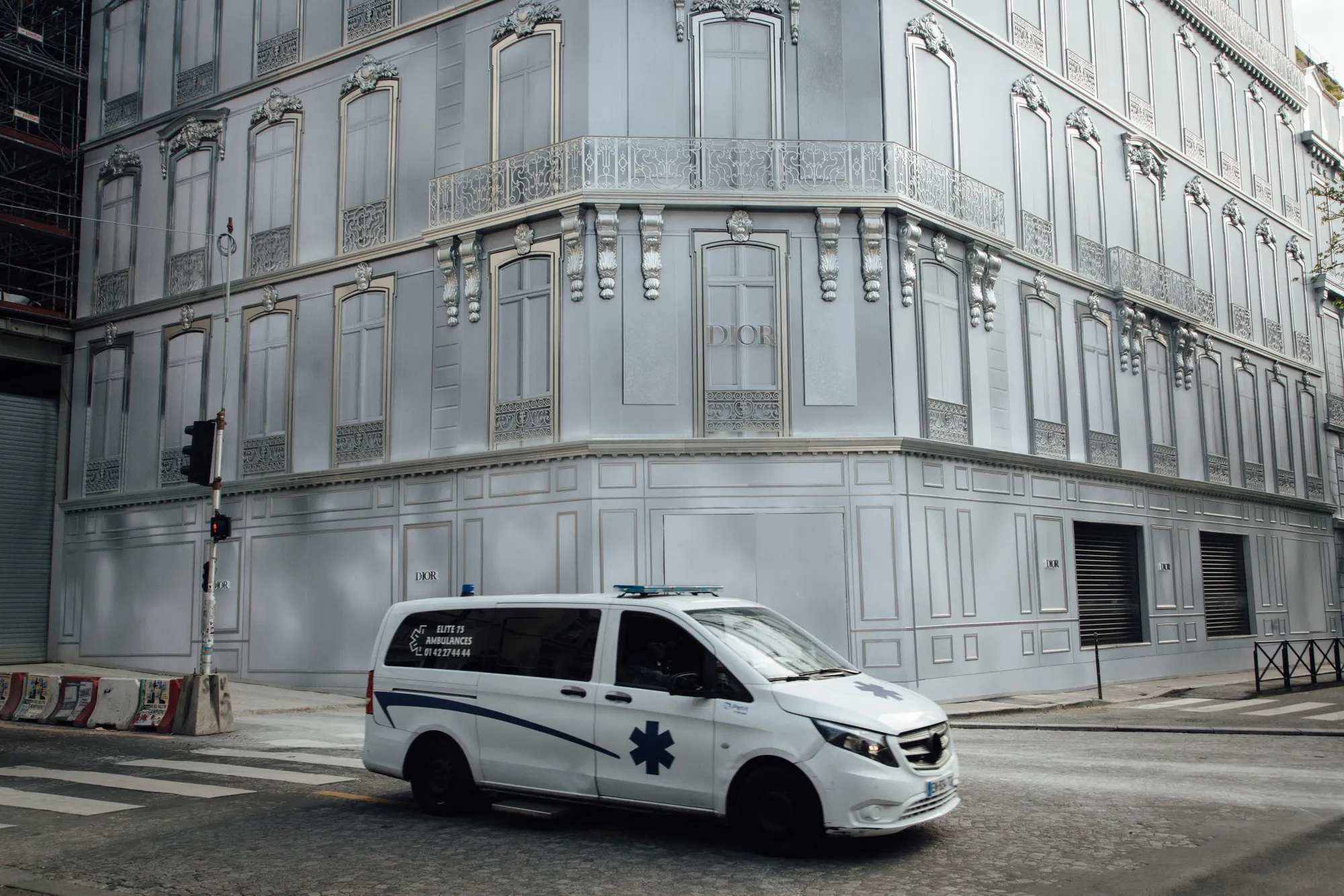 An ambulance passes hoardings covering the Christian Dior SE luxury good store in Paris, on March 17.