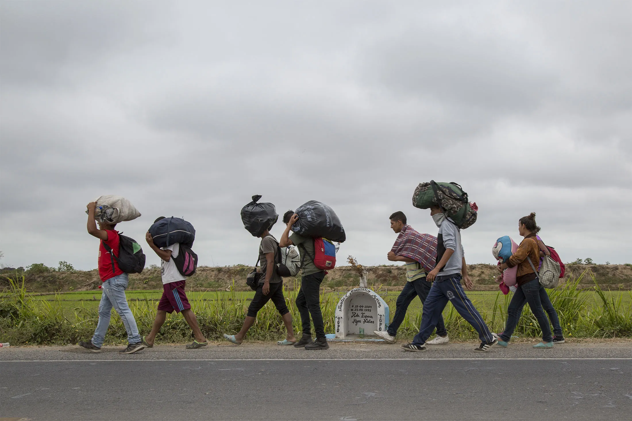 A group of Venezuelan migrants&nbsp;walk along the Panamericana route towards Lima on Aug. 14, in Tumbes, Peru.&nbsp;