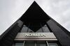 The Nomura Holdings Inc. logo is displayed outside a Nomura Securities Co. branch in Tokyo, Japan.