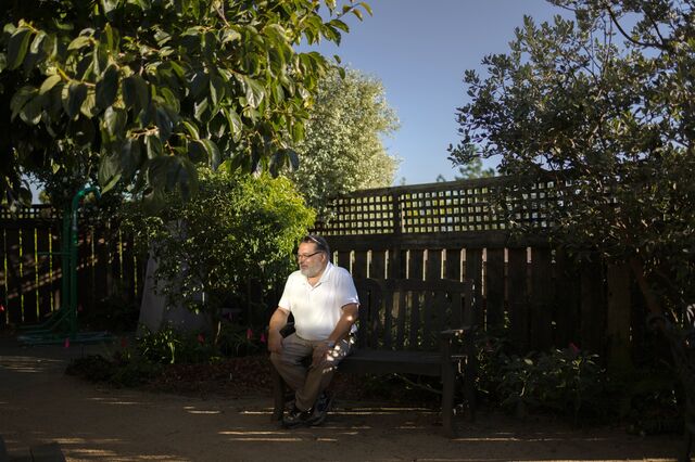 A portrait of Michel Thouati near a persimmon tree in his backyard.