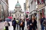 Pedestrians walk along Donegall Place in view of Belfast City Hall in Belfast, Northern Ireland, on&nbsp;April 4, 2018.&nbsp;