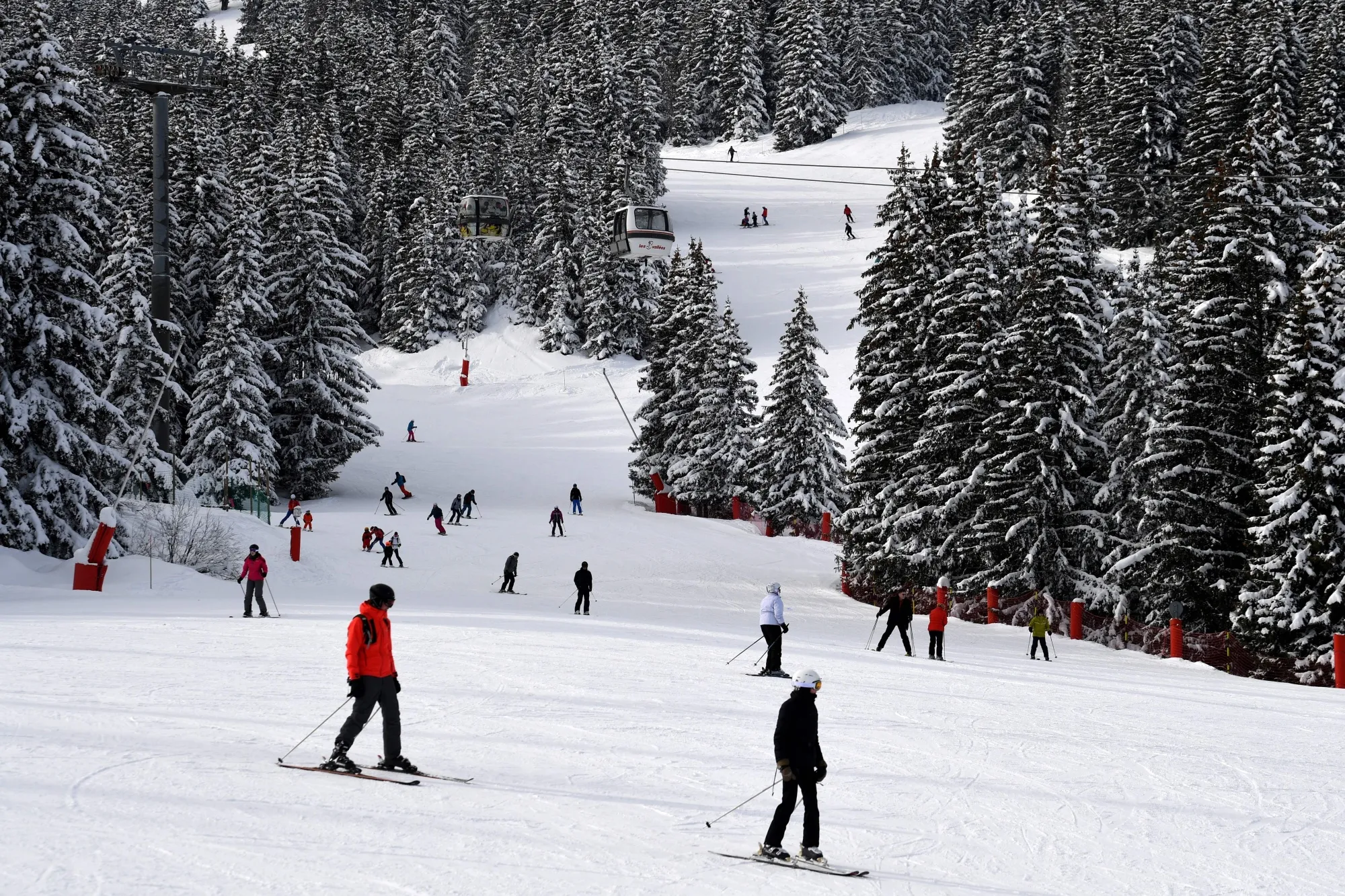 Tourists on ski ride down a slope in the French Alps ski resort of Courchevel.