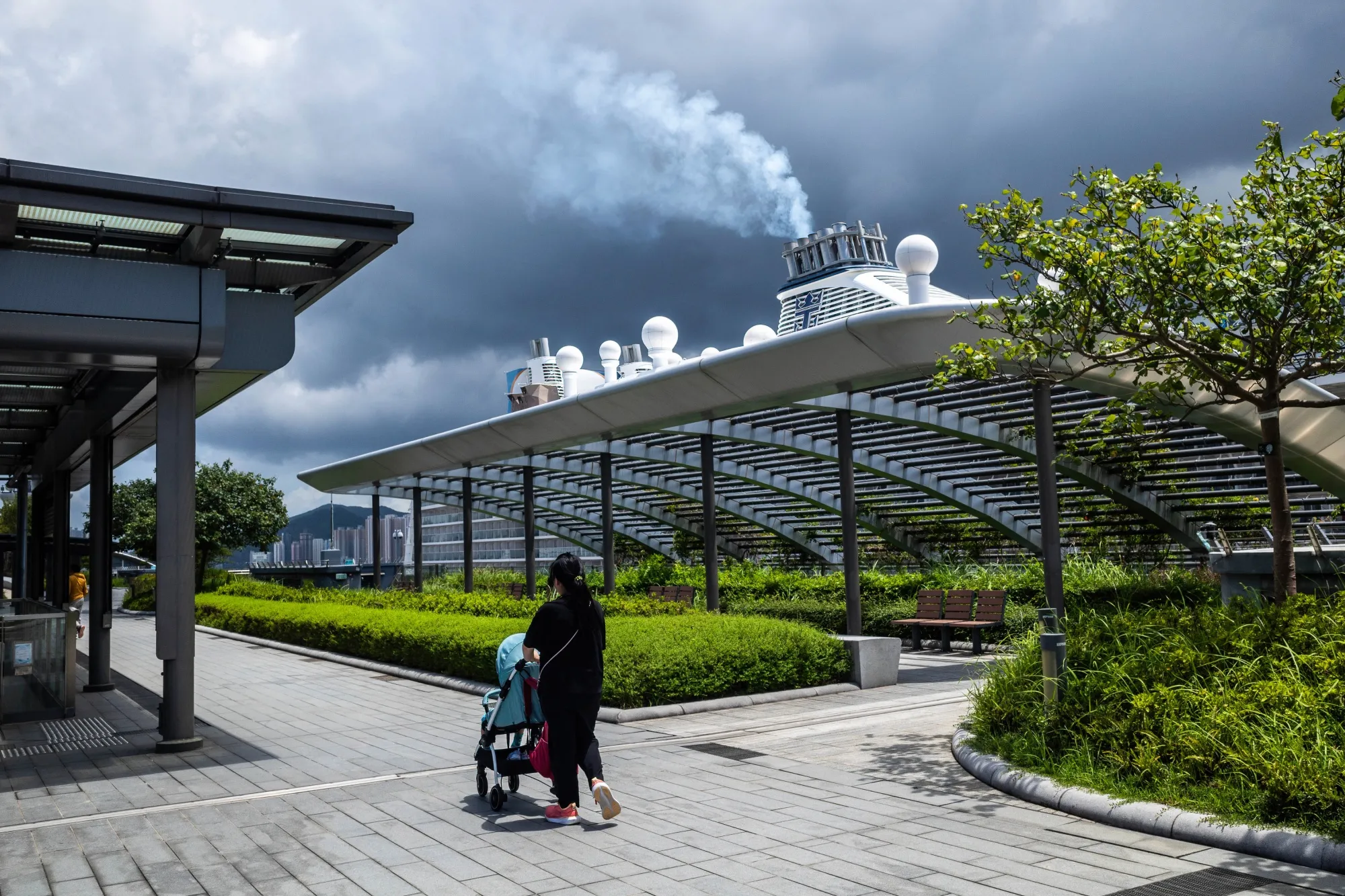 A woman walks a baby along the rooftop park of the Kai Tak Cruise Terminal.