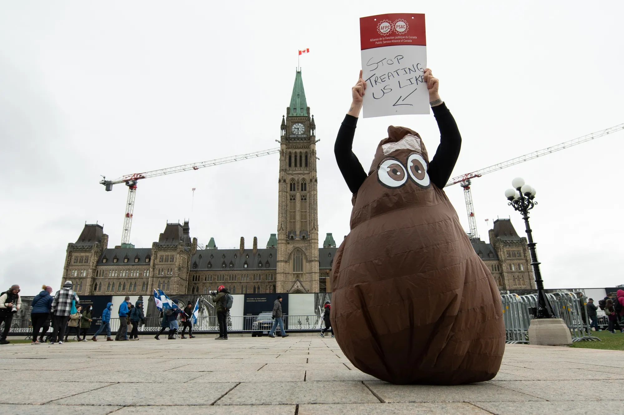 A member of the Public Service Alliance of Canada holds up a placard on the first day of a national strike in Ottawa last week.