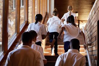 Young students running up stairs at the school