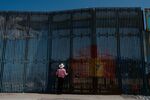 A person stands&nbsp;a section of the U.S. and Mexico border wall on the beach in Tijuana, Mexico.