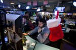 A Christmas stocking hangs next to a trader working on the floor of the New York Stock Exchange (NYSE) in New York, U.S., on Monday, Nov. 28, 2016. 