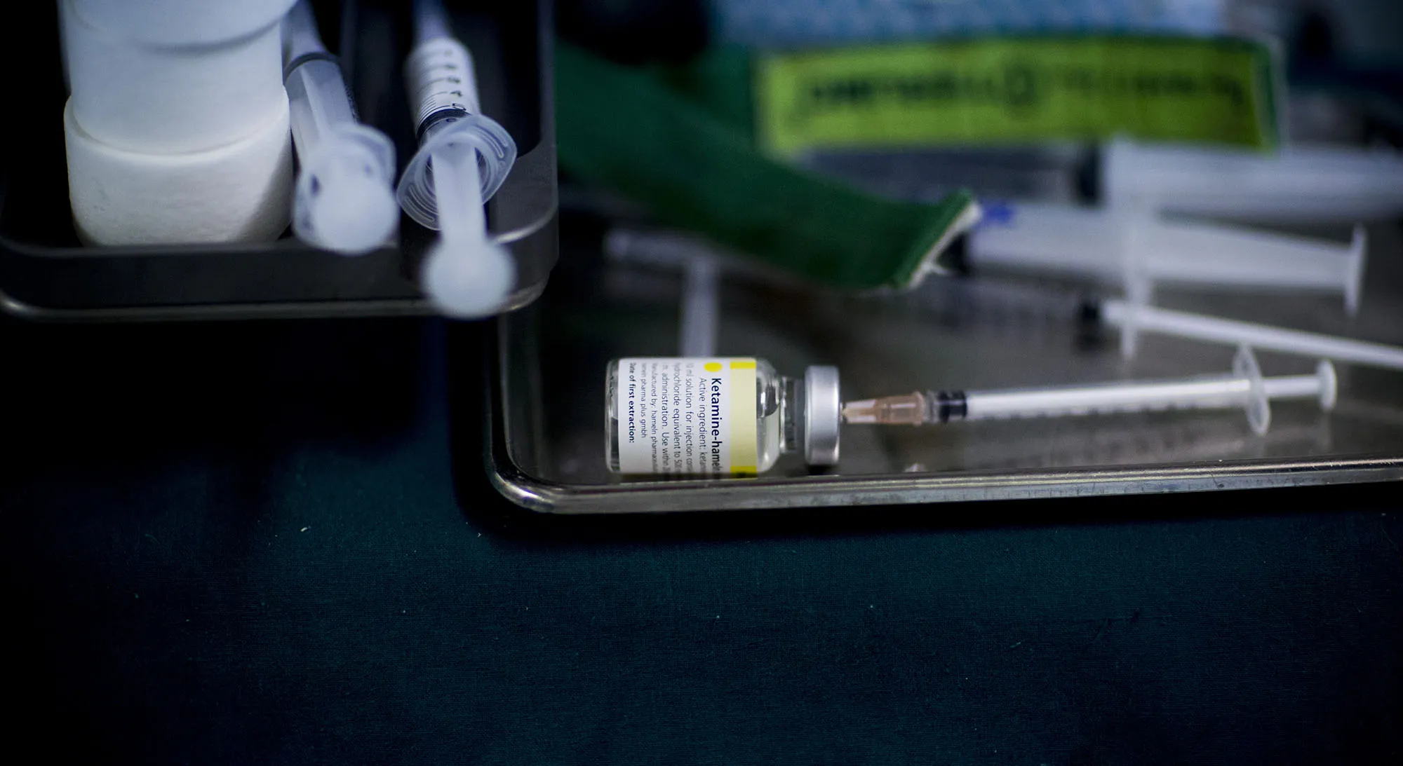 A syringe sits in a bottle of Ketamine.