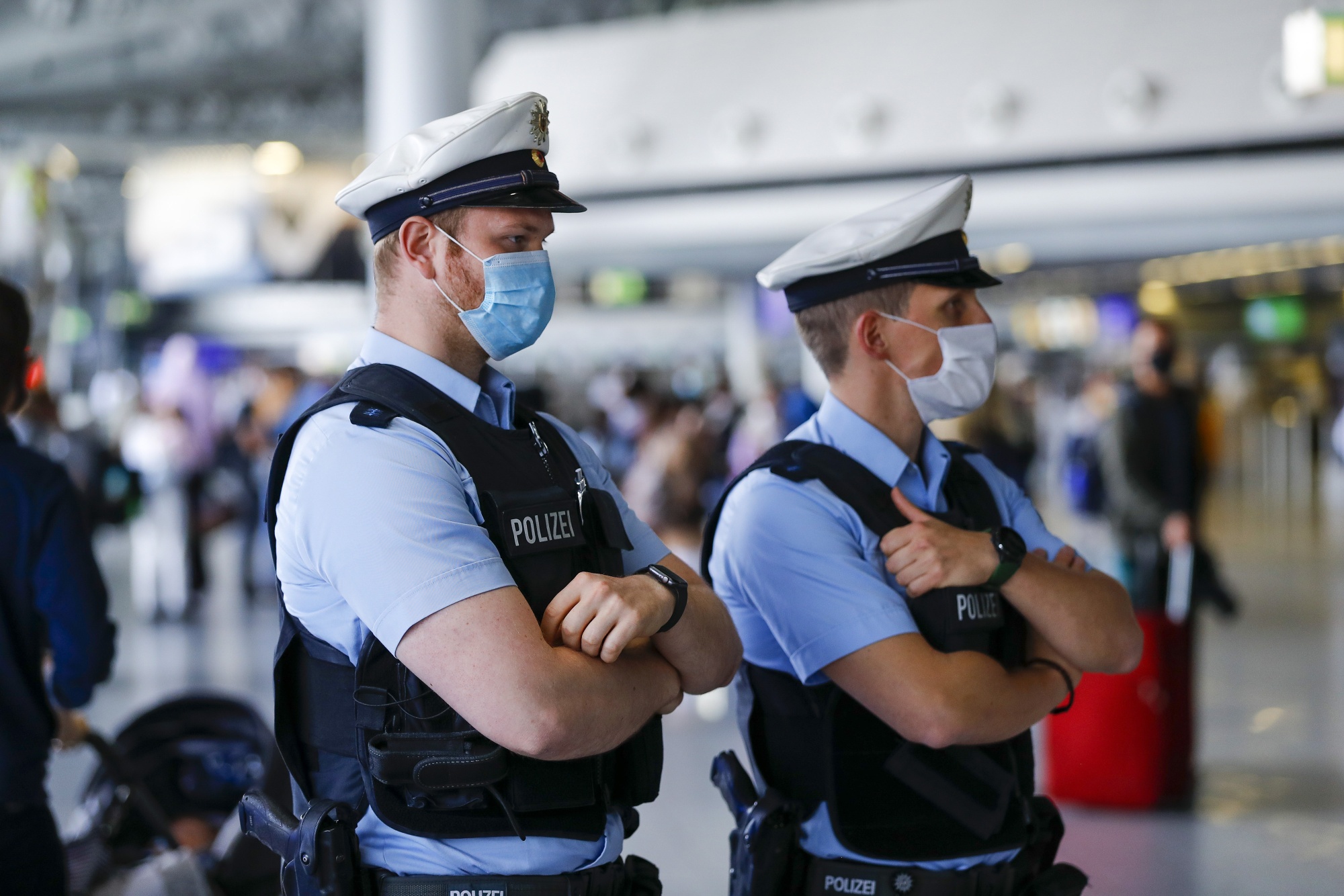 Police officers monitor travelers at Frankfurt Airport in Frankfurt, Germany, on June 17.&nbsp;