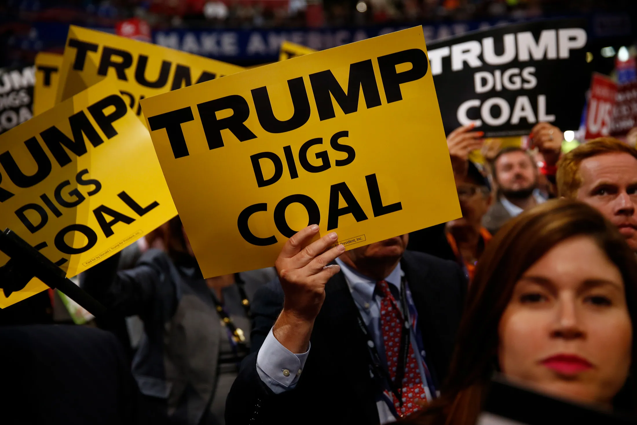 Delegates hold signs reading 'Trump Digs Coal' during the Republican National Convention (RNC) in Cleveland, Ohio, U.S., on Tuesday, July 19, 2016.
