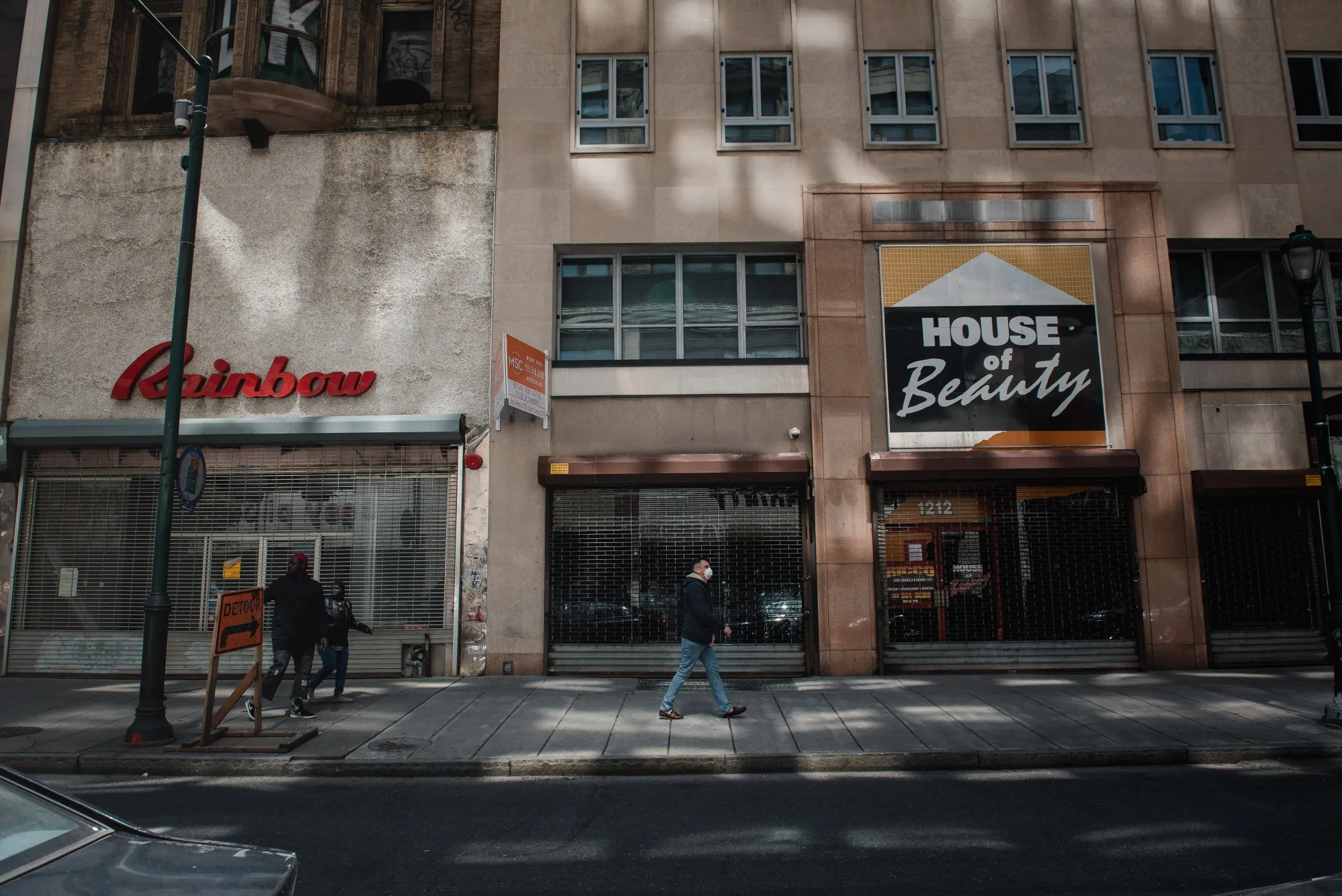 A pedestrian&nbsp;walks by closed shops in Center City in Philadelphia on April 15.