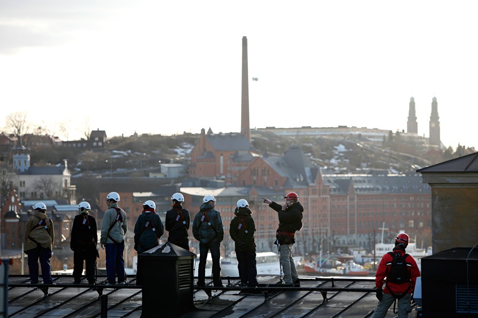 A guide leads some intrepid tourists across the roof of Stockholm's Old Parliament Building.