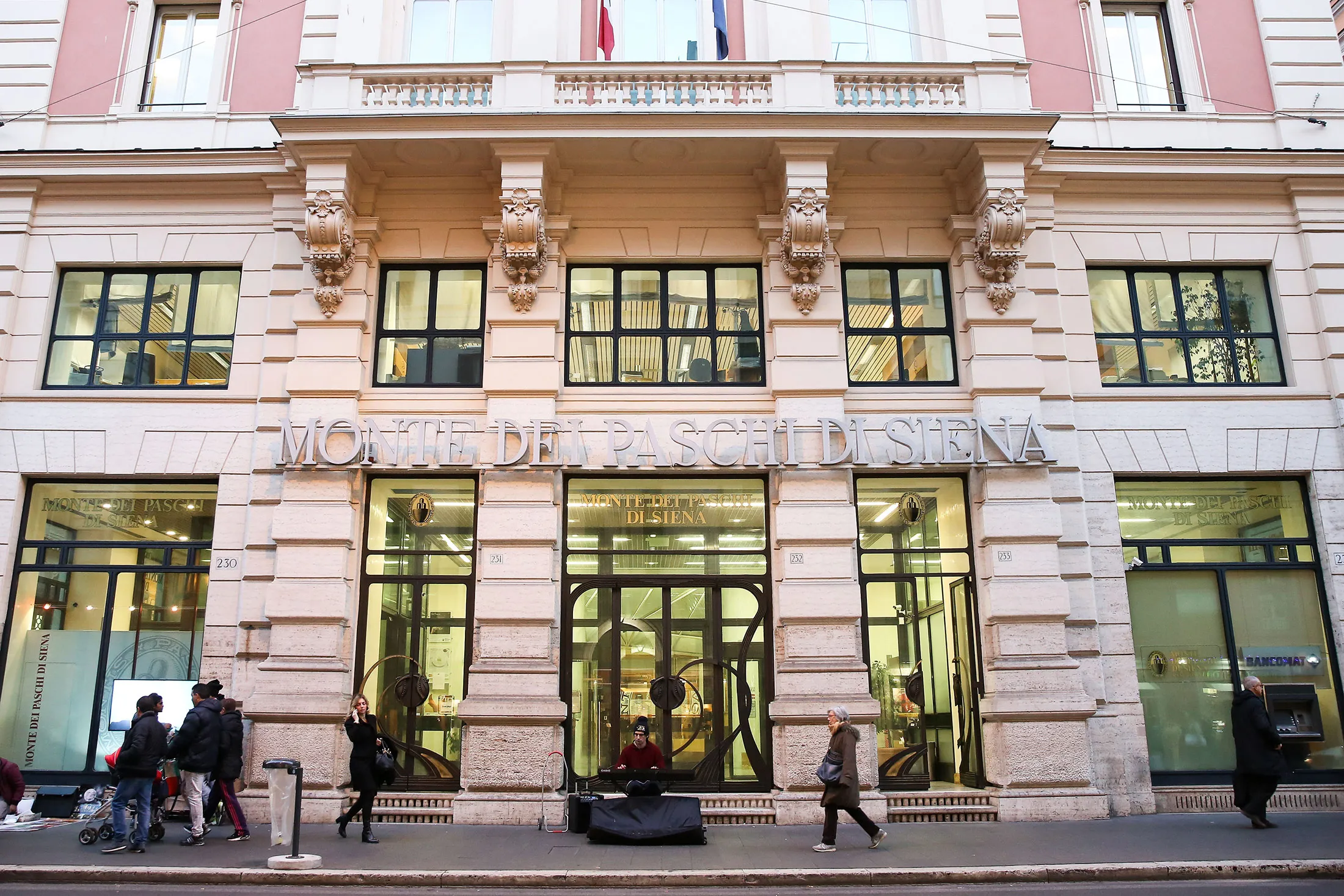 Pedestrians pass a Banca Monte dei Paschi di Siena SpA bank branch in Rome, Italy, on Wednesday, Jan. 27, 2016. Italy's banking woes are set to plague Prime Minister Matteo Renzi for months to come after a long-sought deal with the European Union on bad debts disappointed investors.
