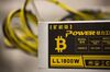A bitcoin logo sits on a LL 1800W power unit supplying cryptocurrency mining machines at the SberBit mining 'hotel.'
