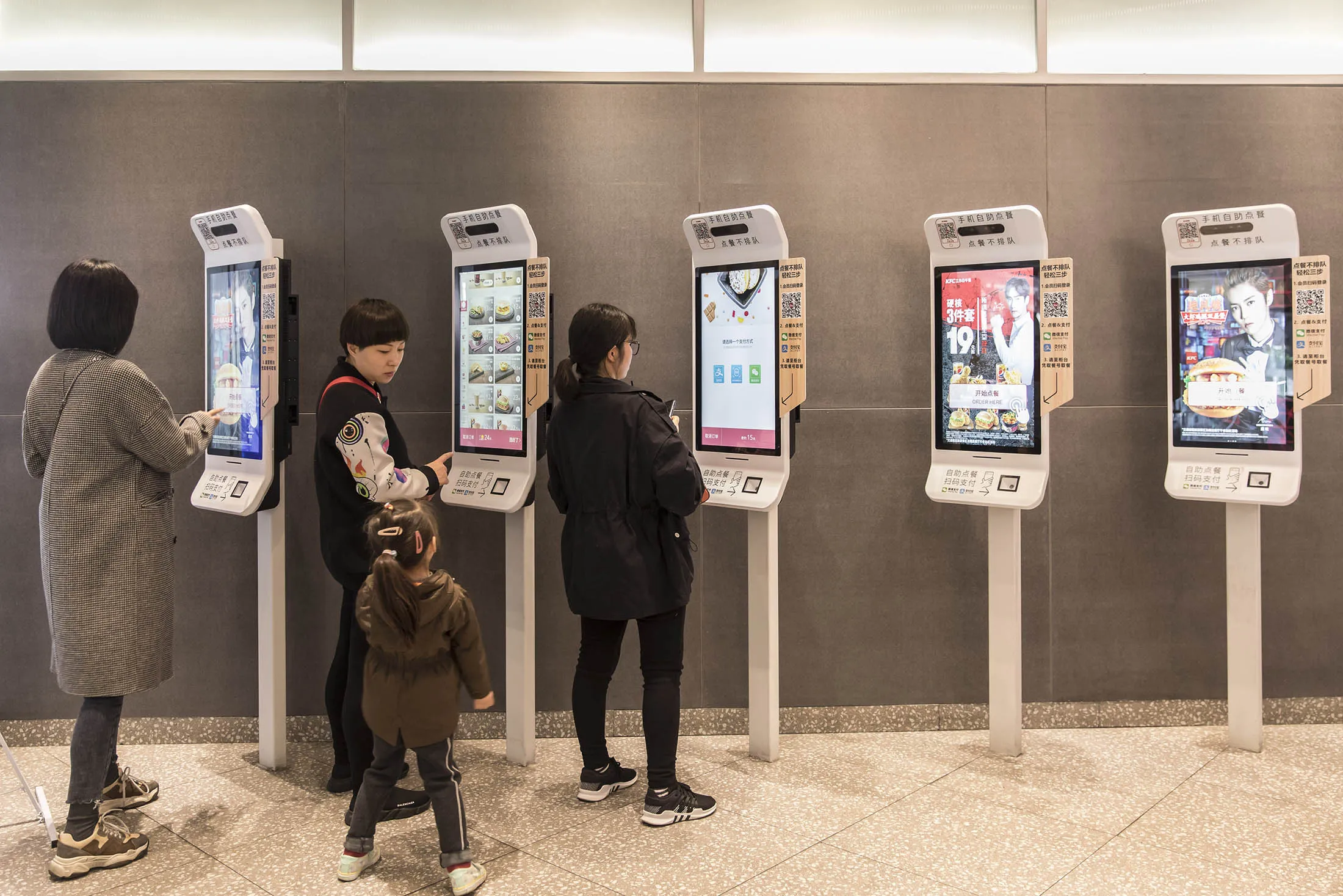 Customers use touch screen displays to order a meal at a&nbsp;KFC restaurant in Shanghai.